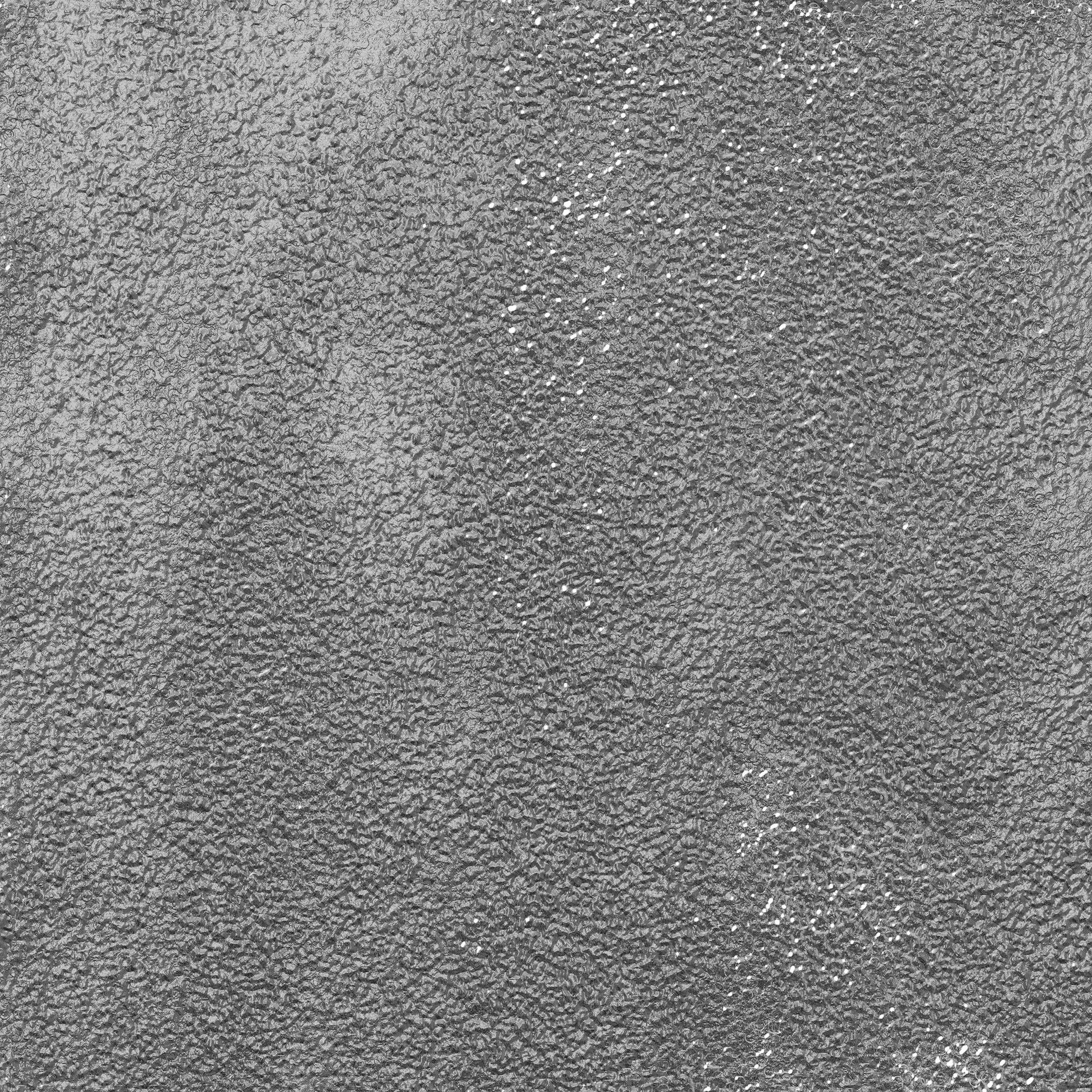 Textured gray surface with small, raised particles.