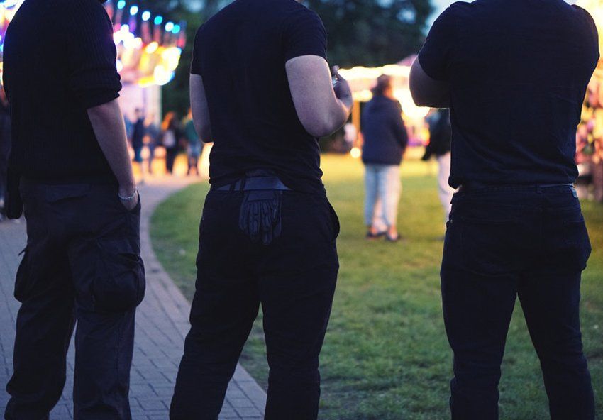 Midsection Of Bouncers Standing At Garden Party