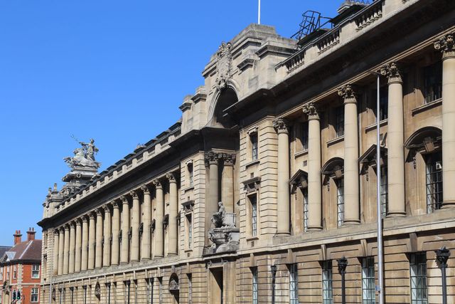 Stone building with ornate columns and architectural details against a clear blue sky.