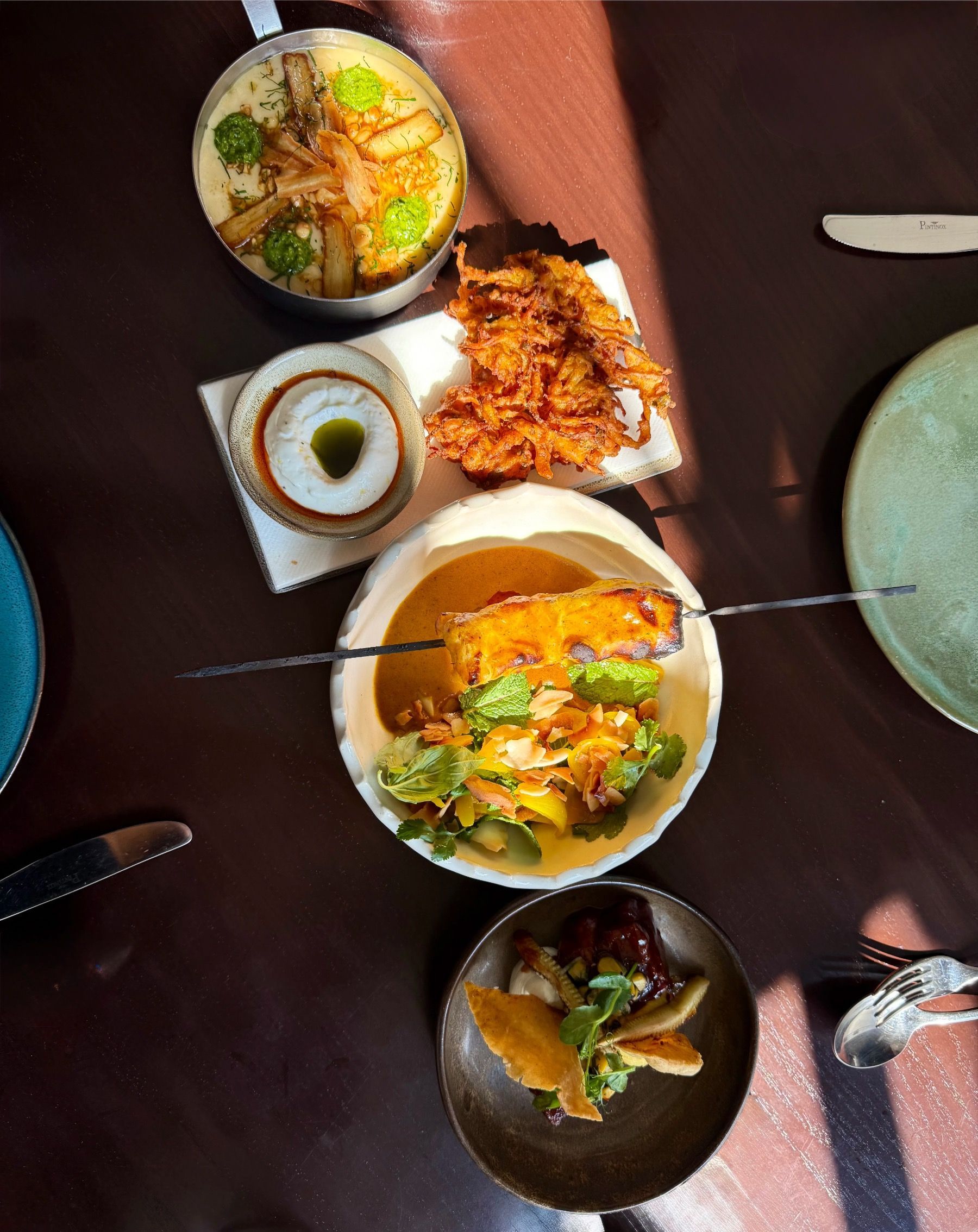 Overhead view of main dishes at Chefs Warehouse & Canteen featuring refined small plate sharing menu.
