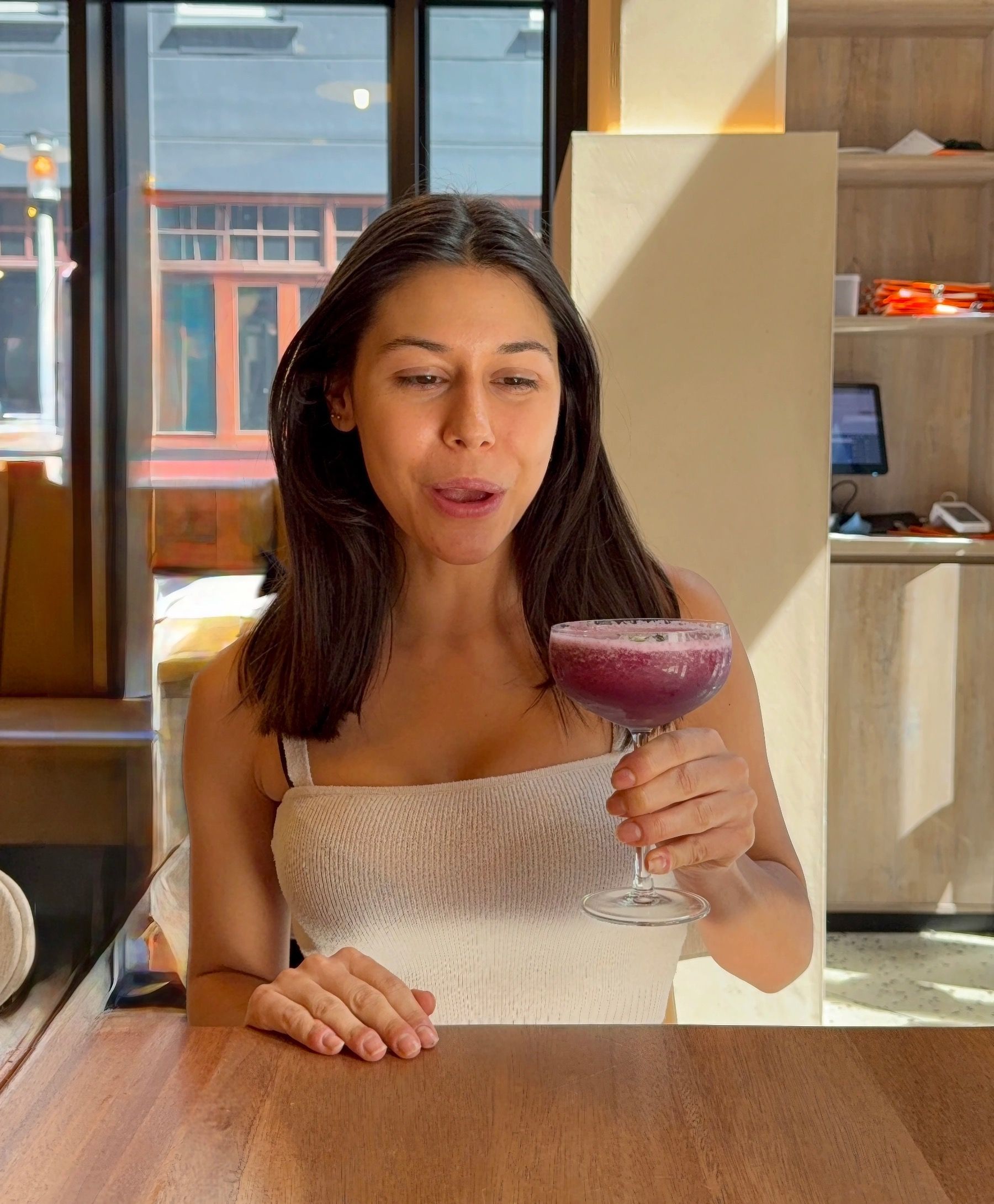 Paige holding and sipping No. 87 cocktail at Florentin restaurant