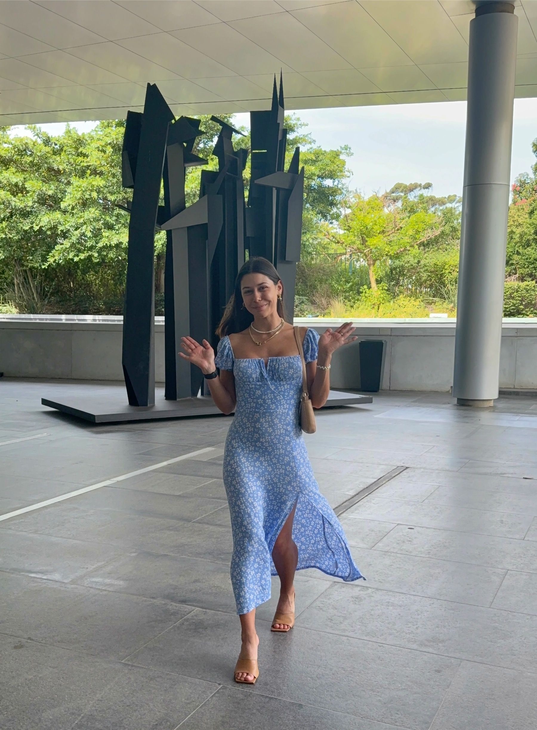 Paige Ellis Green waving in front of Norval Foundation sculpture wall before lunch at Grub & Vine Norval