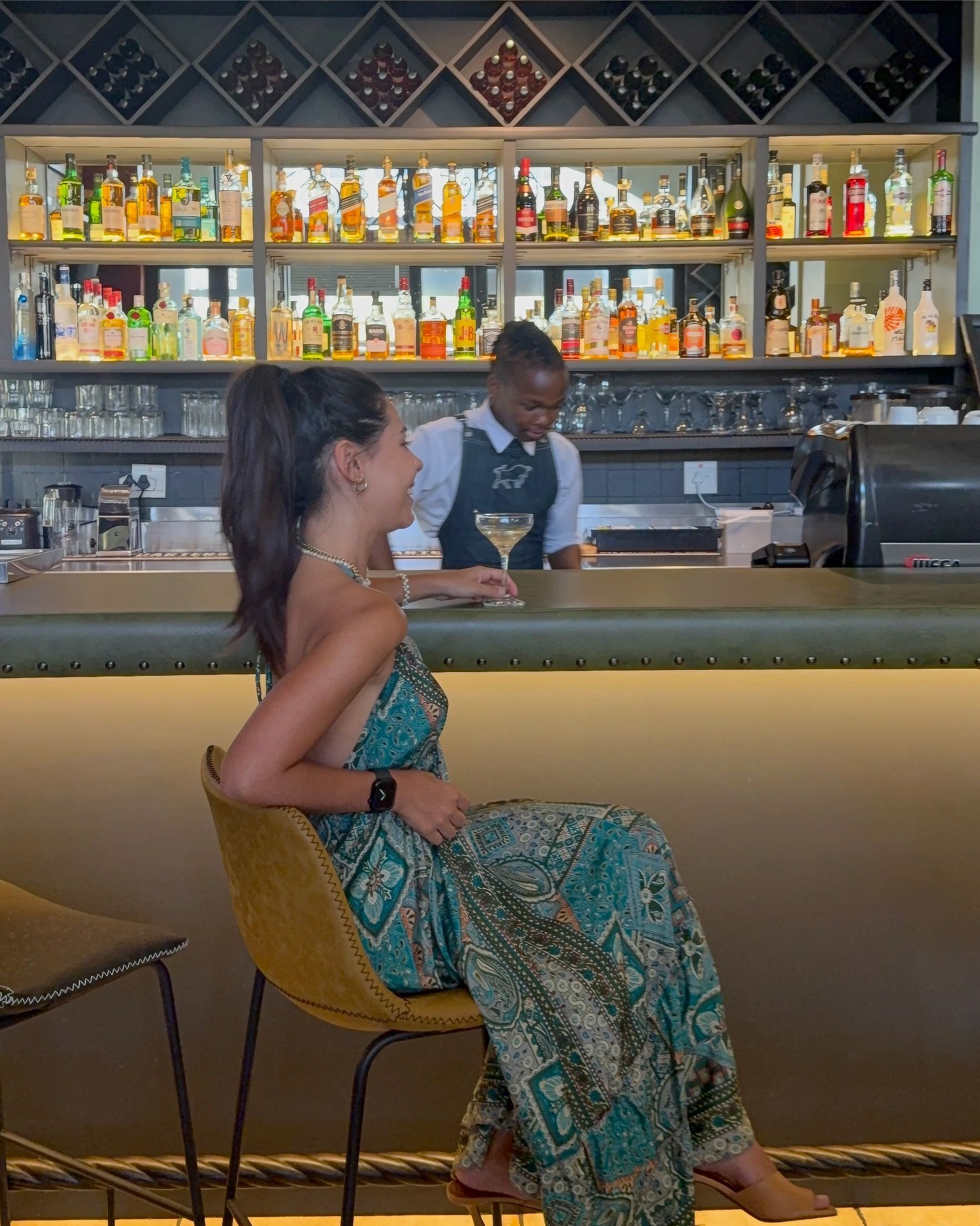 Paige seated at the HQ Steakhouse bar in Century City, elegant steakhouse setting with polished modern interior