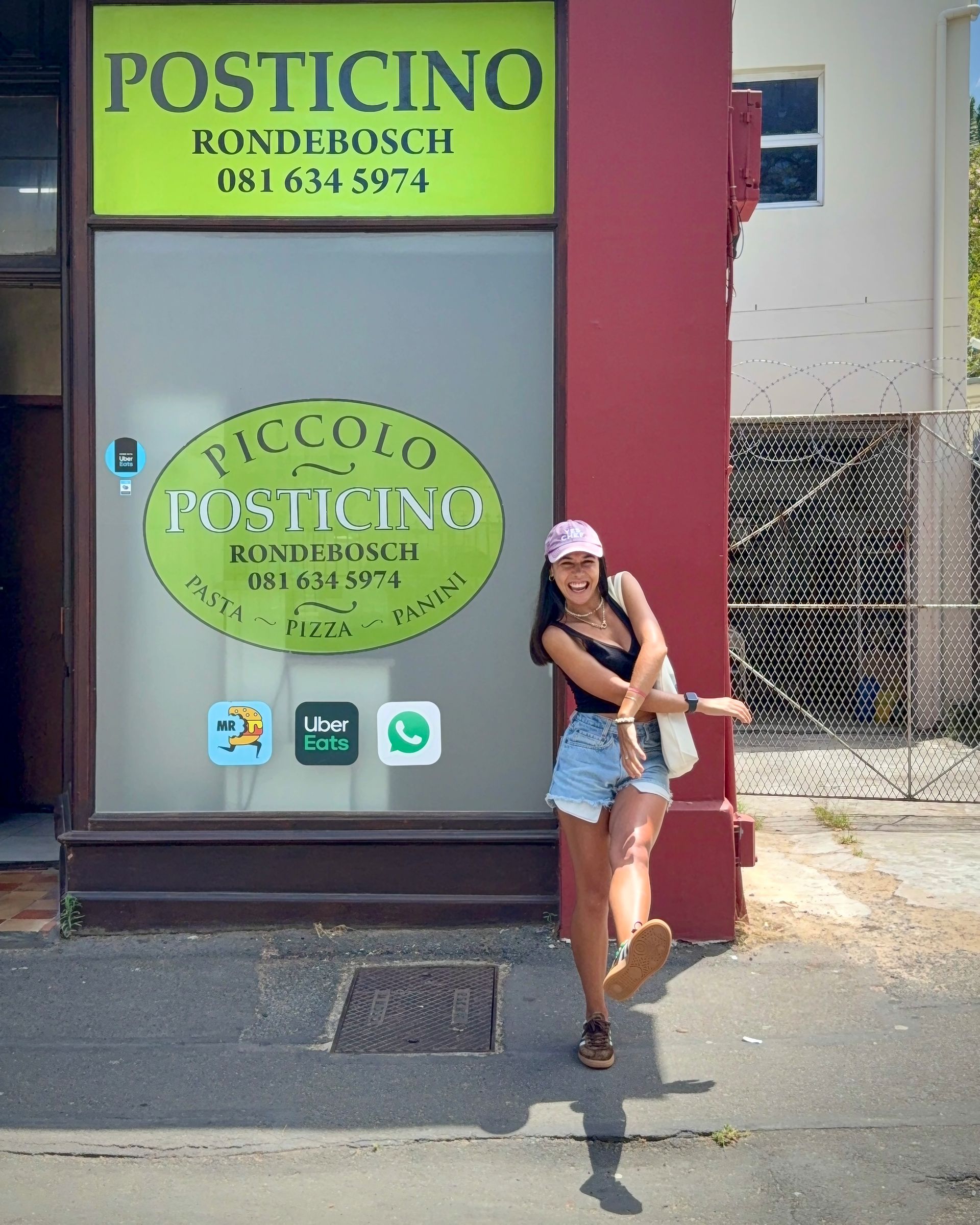 Woman posing in front of a restaurant, 