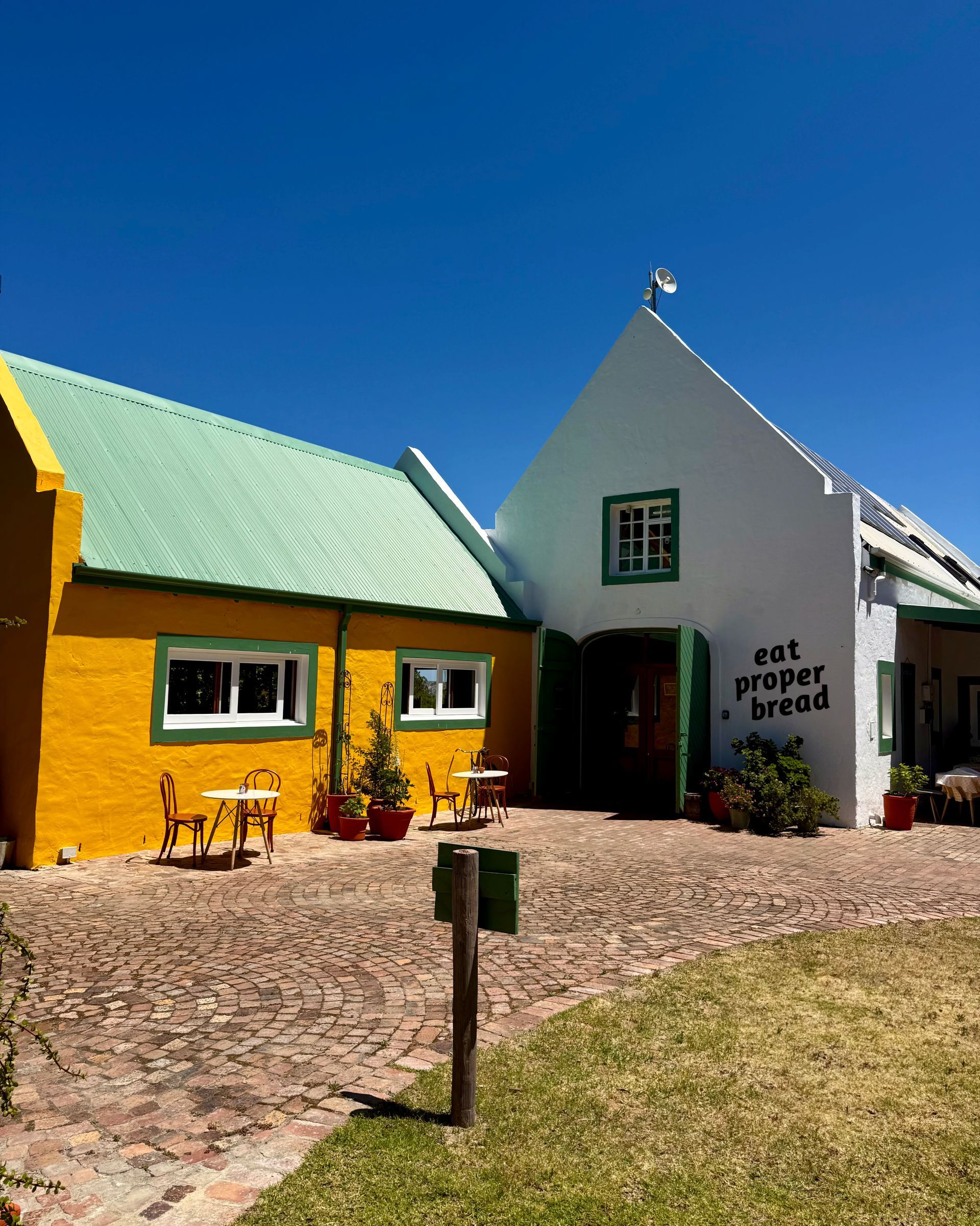Buildings: yellow & white facade, green roof, 
