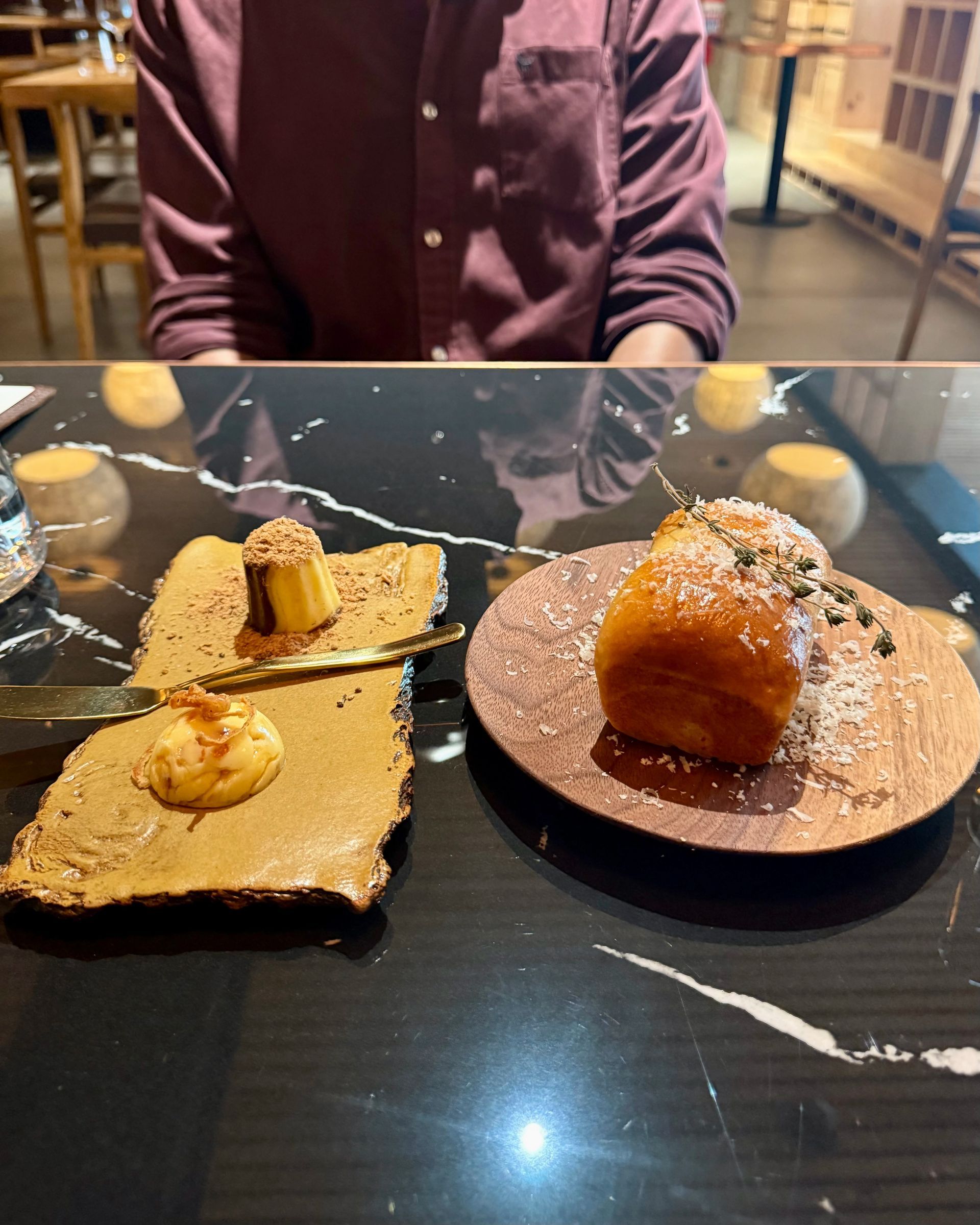 Sushi dish with a round tower of ingredients on a plate, dark sauce, small bowl in background.