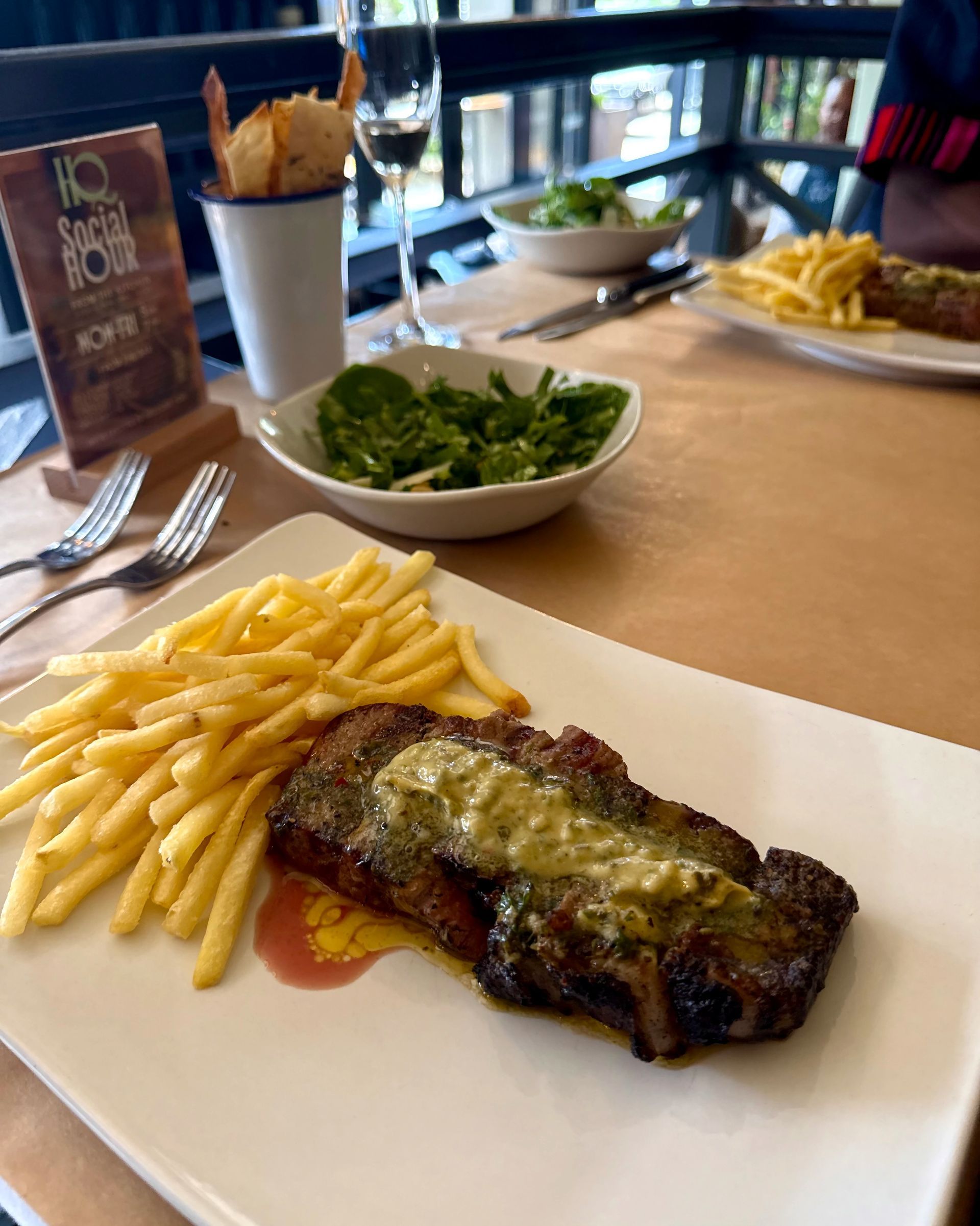 Grilled steak with fries and greens on a plate at HQ Steakhouse in Cape Town