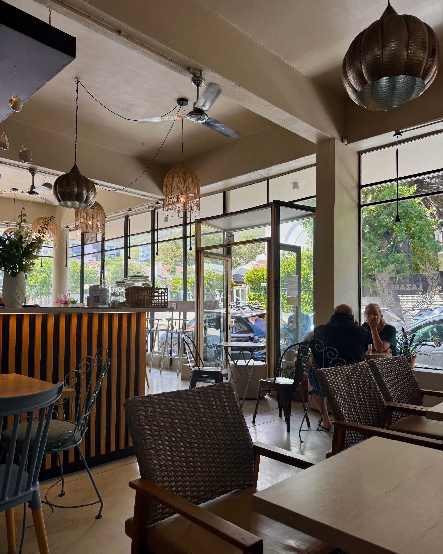 Interior of Lazari Café in Gardens, Cape Town, with warm wooden tables, natural light and relaxed brunch atmosphere