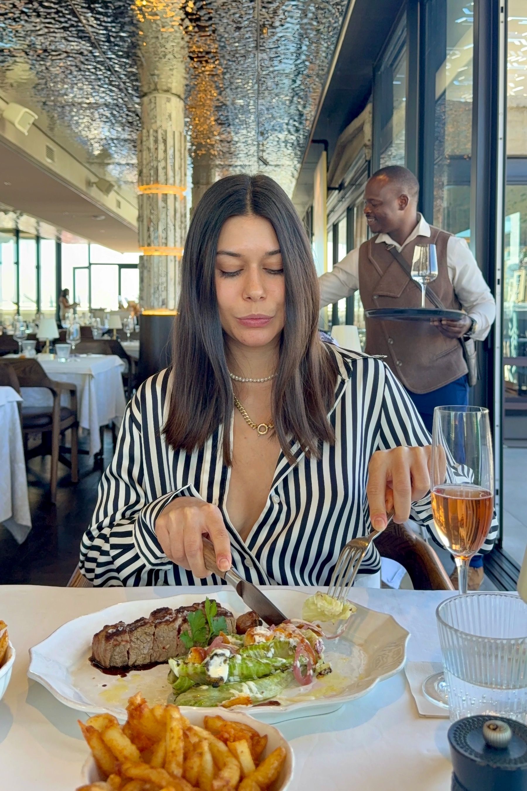 Paige dining at Marble Cape Town, cutting into sirloin steak during Restaurant Week at the V&A Waterfront