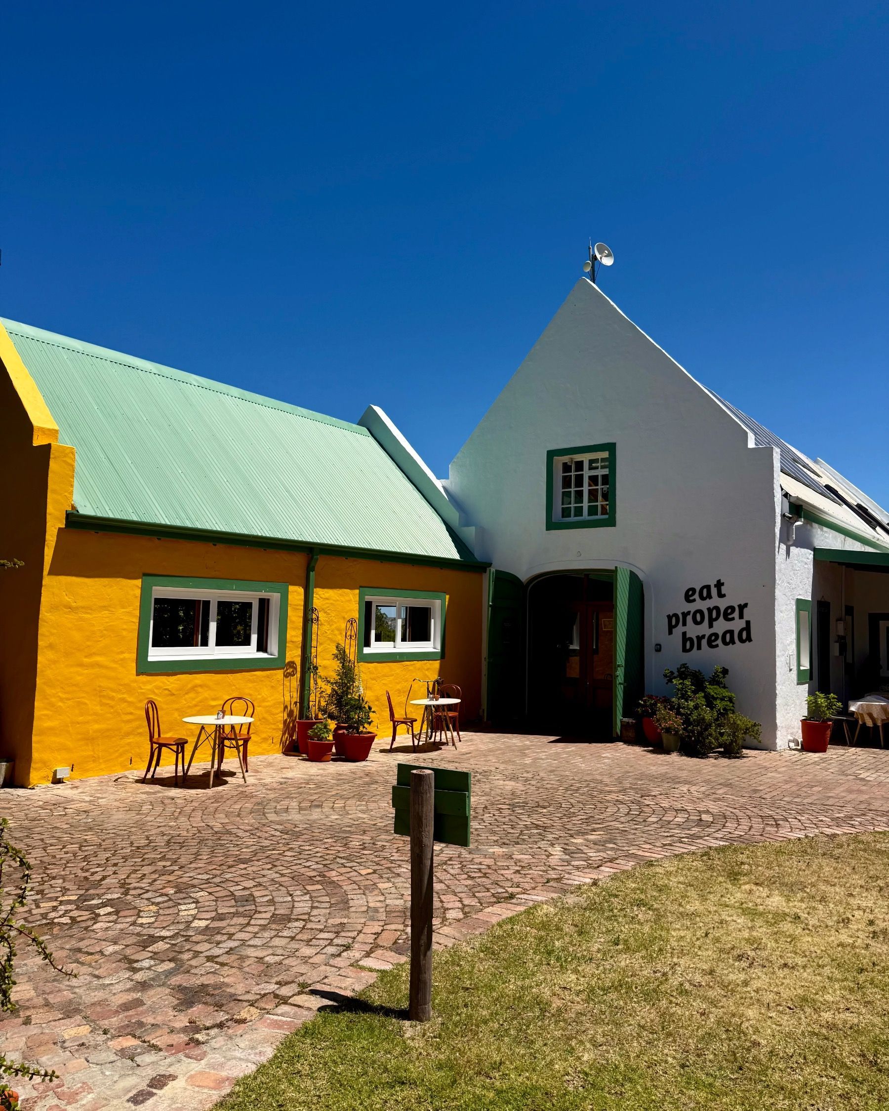 Exterior entrance of Motherdough bakery in Jonkershoek, Stellenbosch, set on a farm with Cape Dutch-inspired building