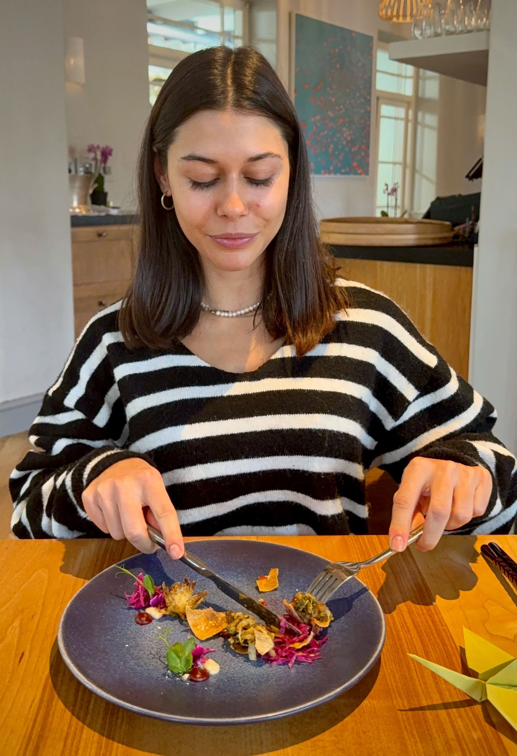 Paige tasting charred cabbage course at Oku Franschhoek.