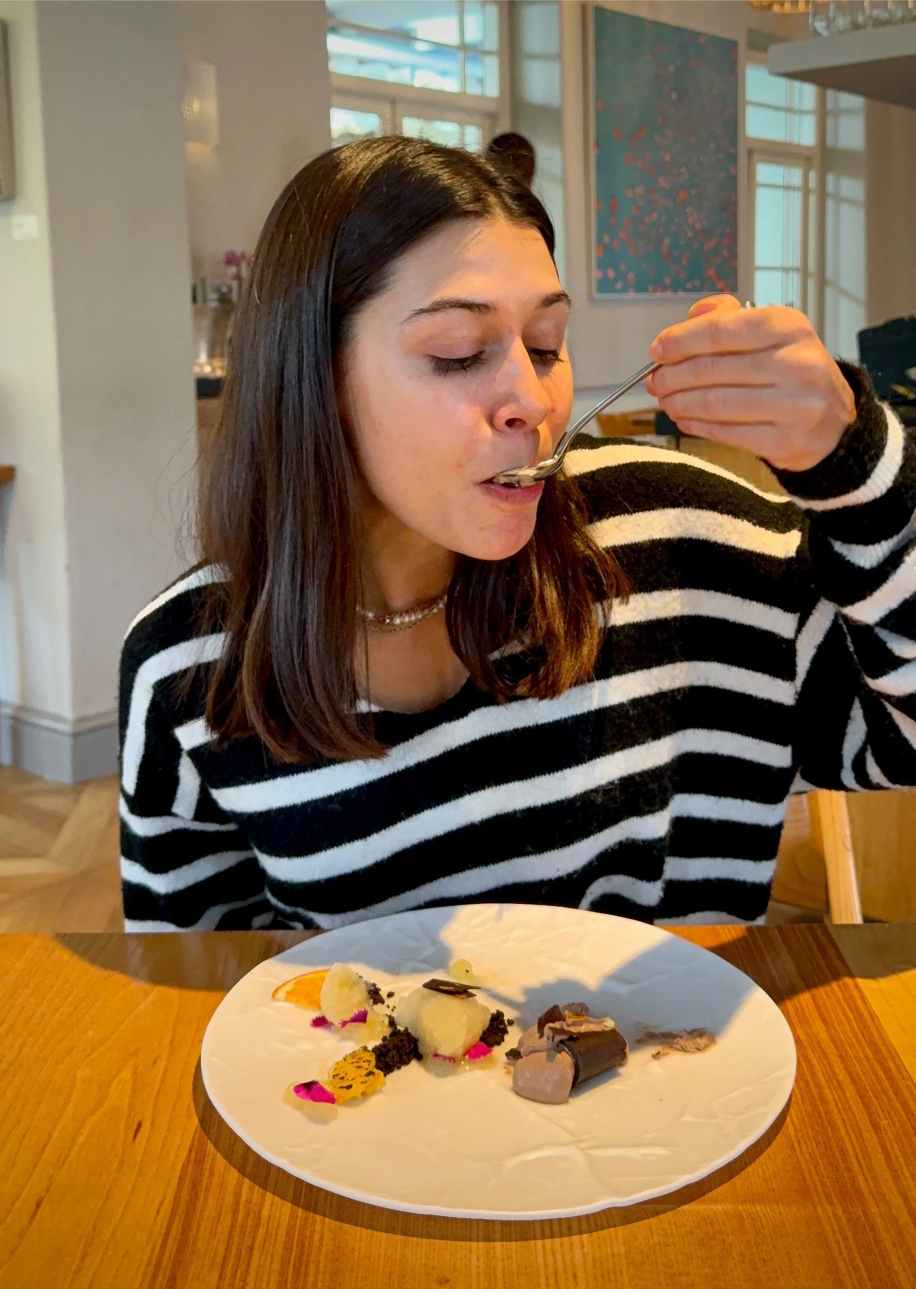 Paige tasting dark chocolate dessert at Oku tasting menu.