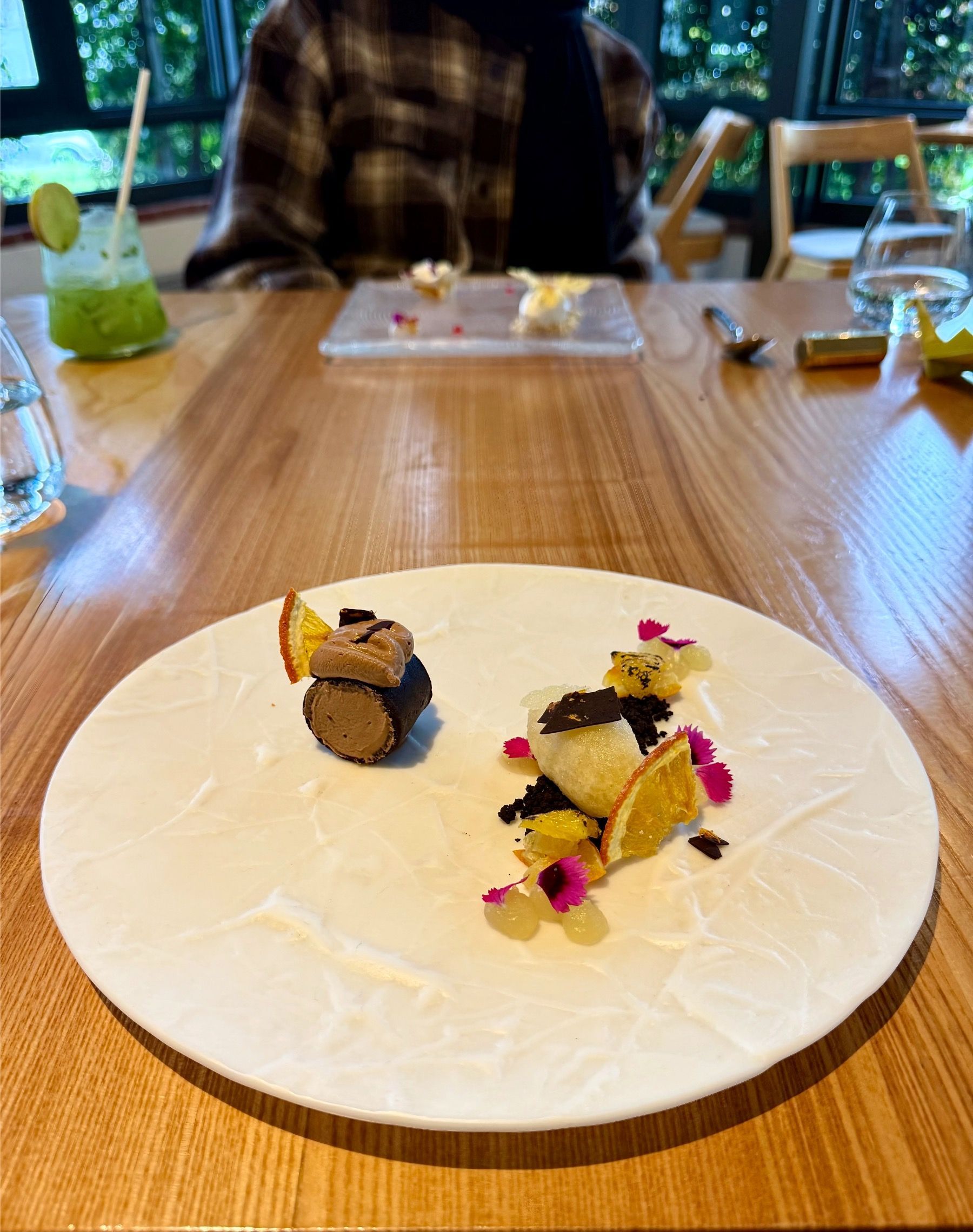 Dark chocolate mousse with delicate garnish on a matte black plate at Oku Franschhoek.