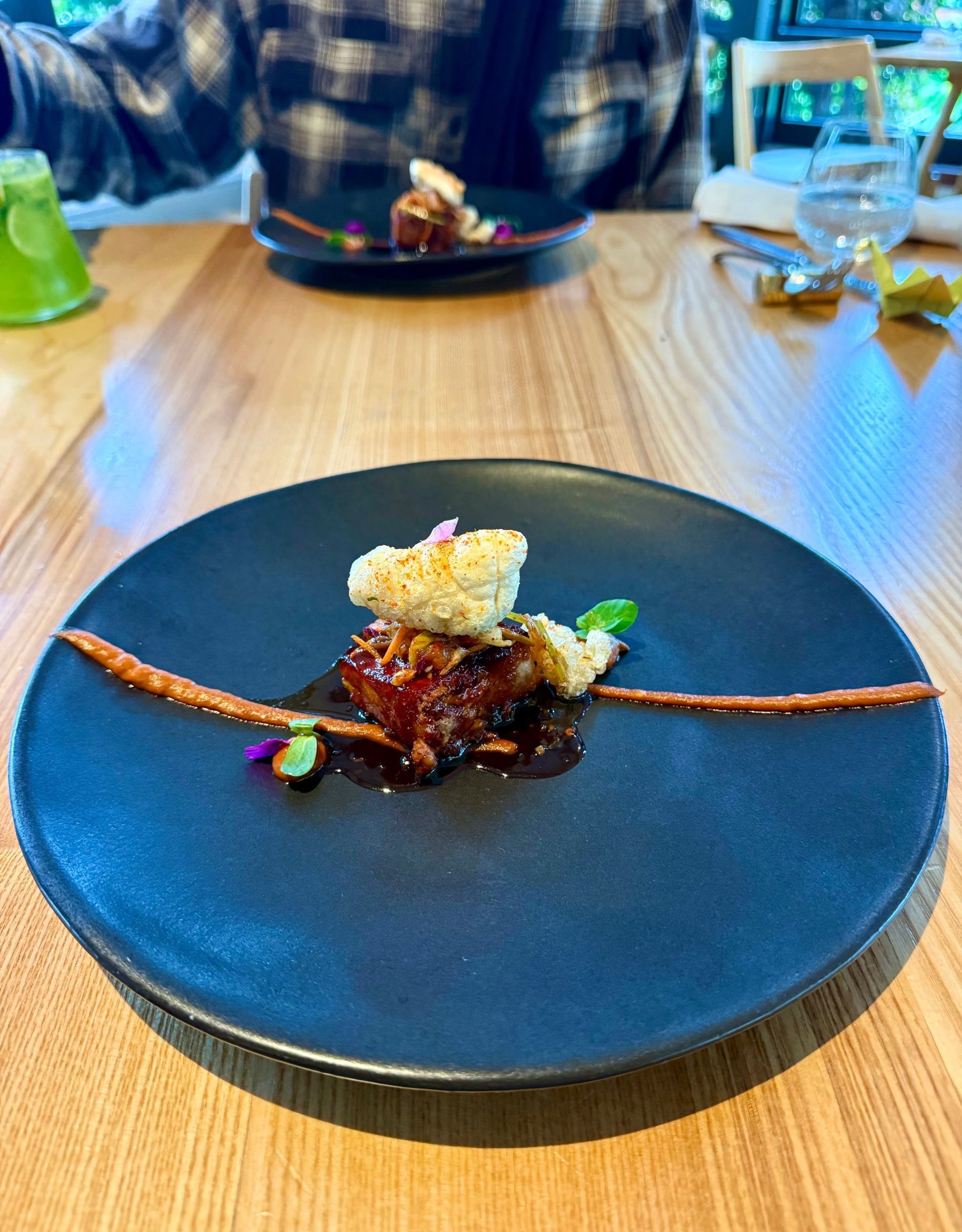 Pork rib yakinuki with glossy sauce and precise plating on a dark ceramic plate.