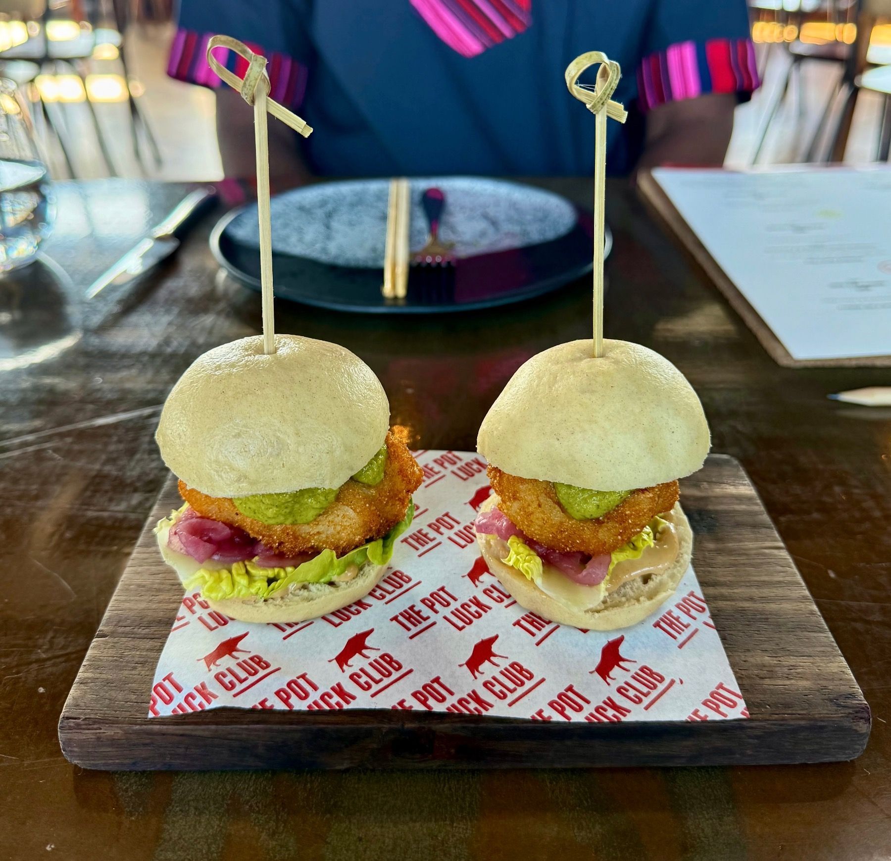 Pot Luck Club fish sliders served on  buns with sauce
