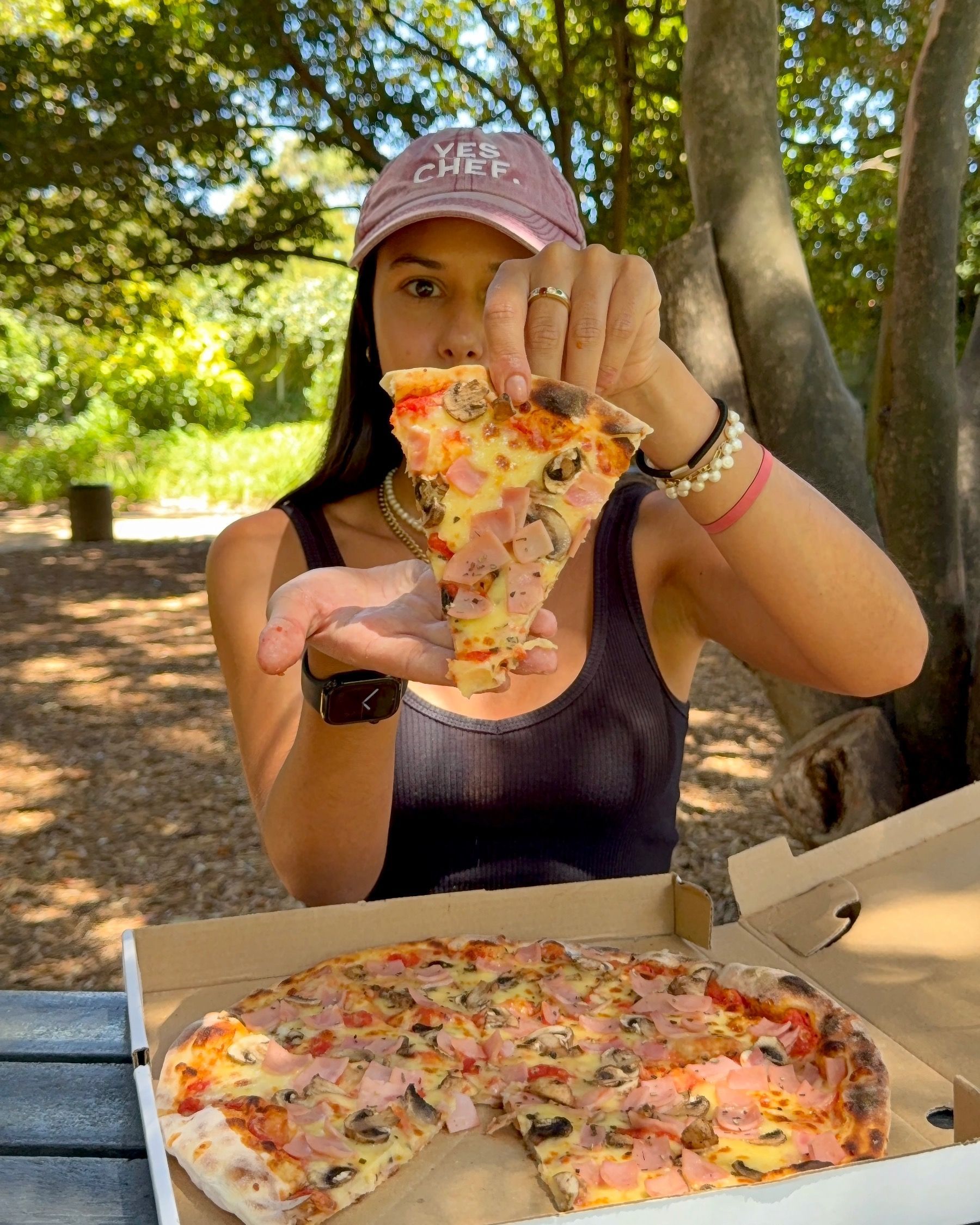 Paige holding a slice of Regina pizza from Piccolo Posticino Rondebosch