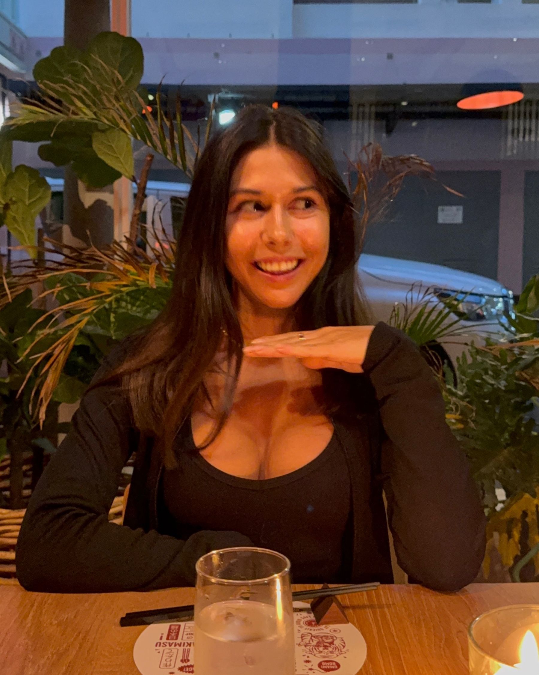 Paige is smiling at Ramenhead Cape Town with sparkling water