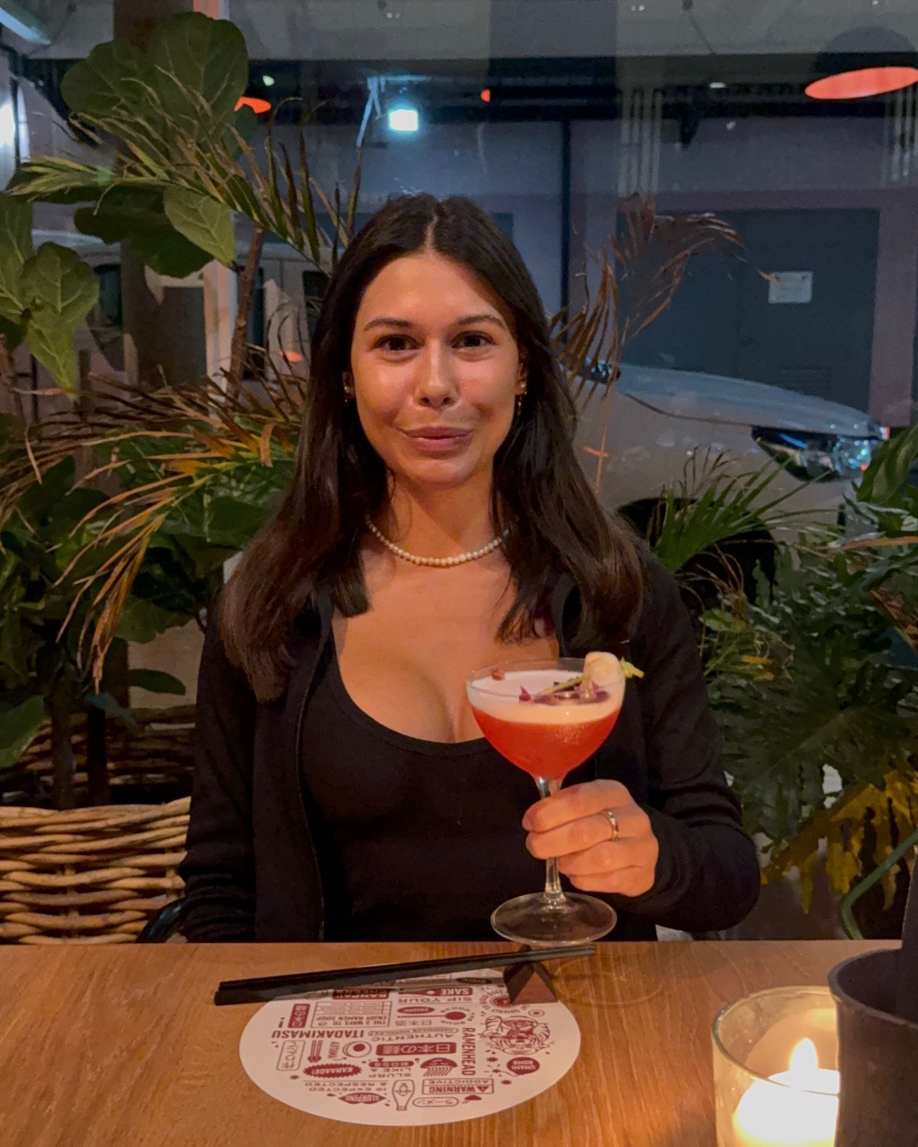 Paige is holding a lychee rose martini at Ramenhead Cape Town