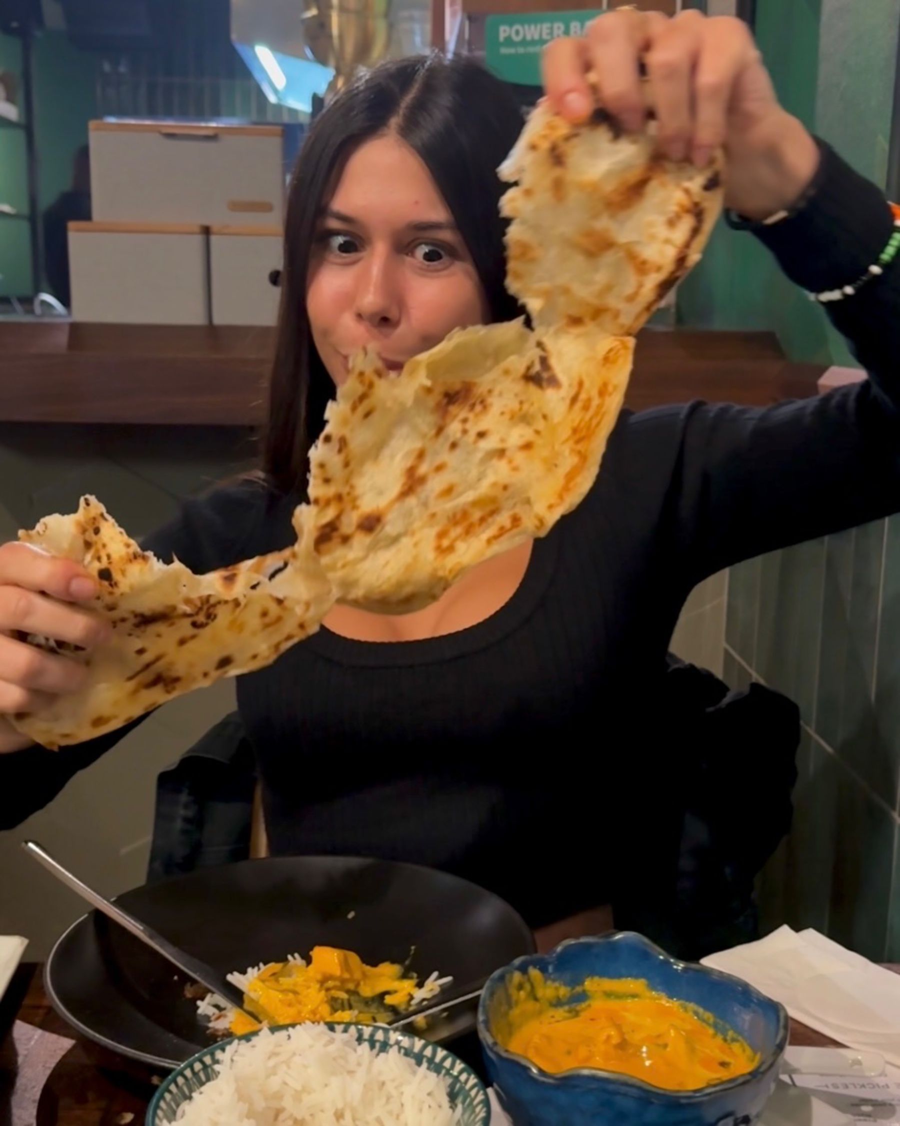 Paige is eating butter chicken and paratha at Sundoo Sea Point