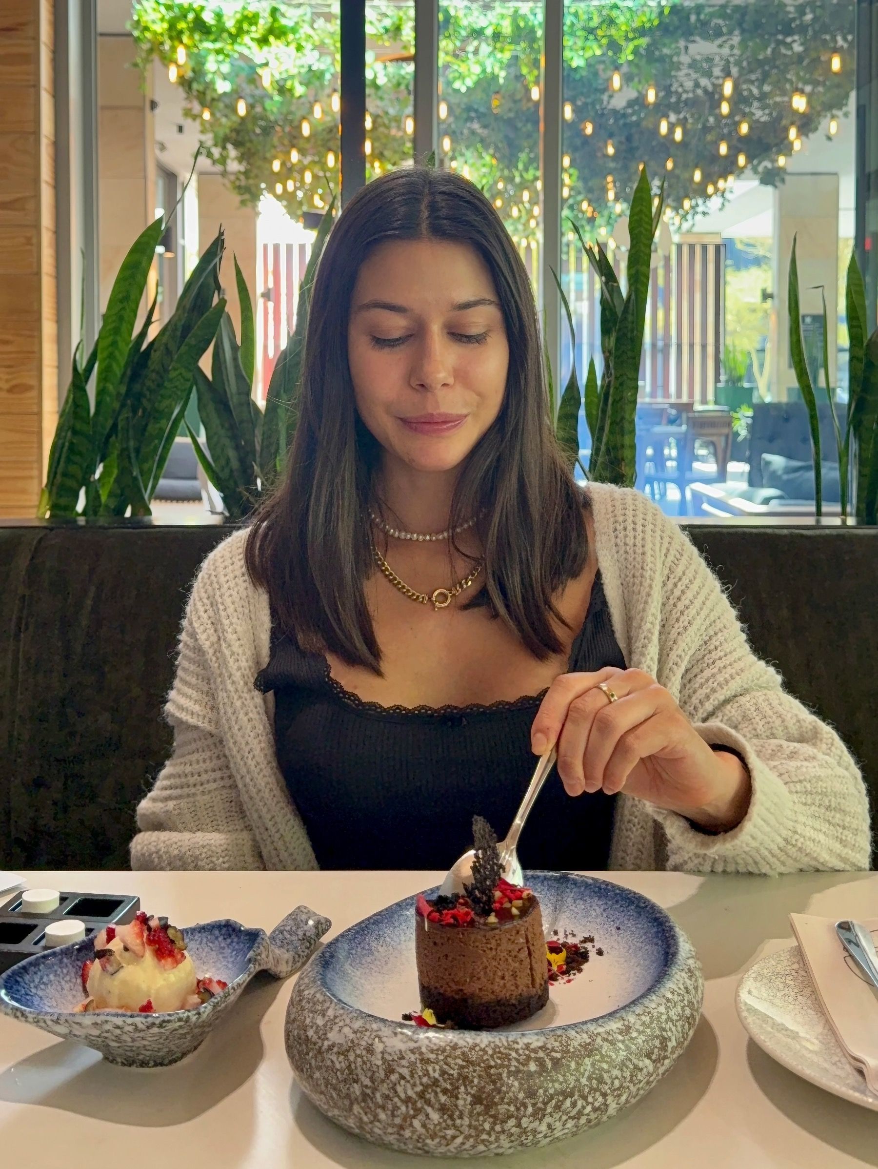 Paige is cutting into the decadent mud pie dessert at Urban Umami, revealing rich chocolate mousse and forest gravel crumble.