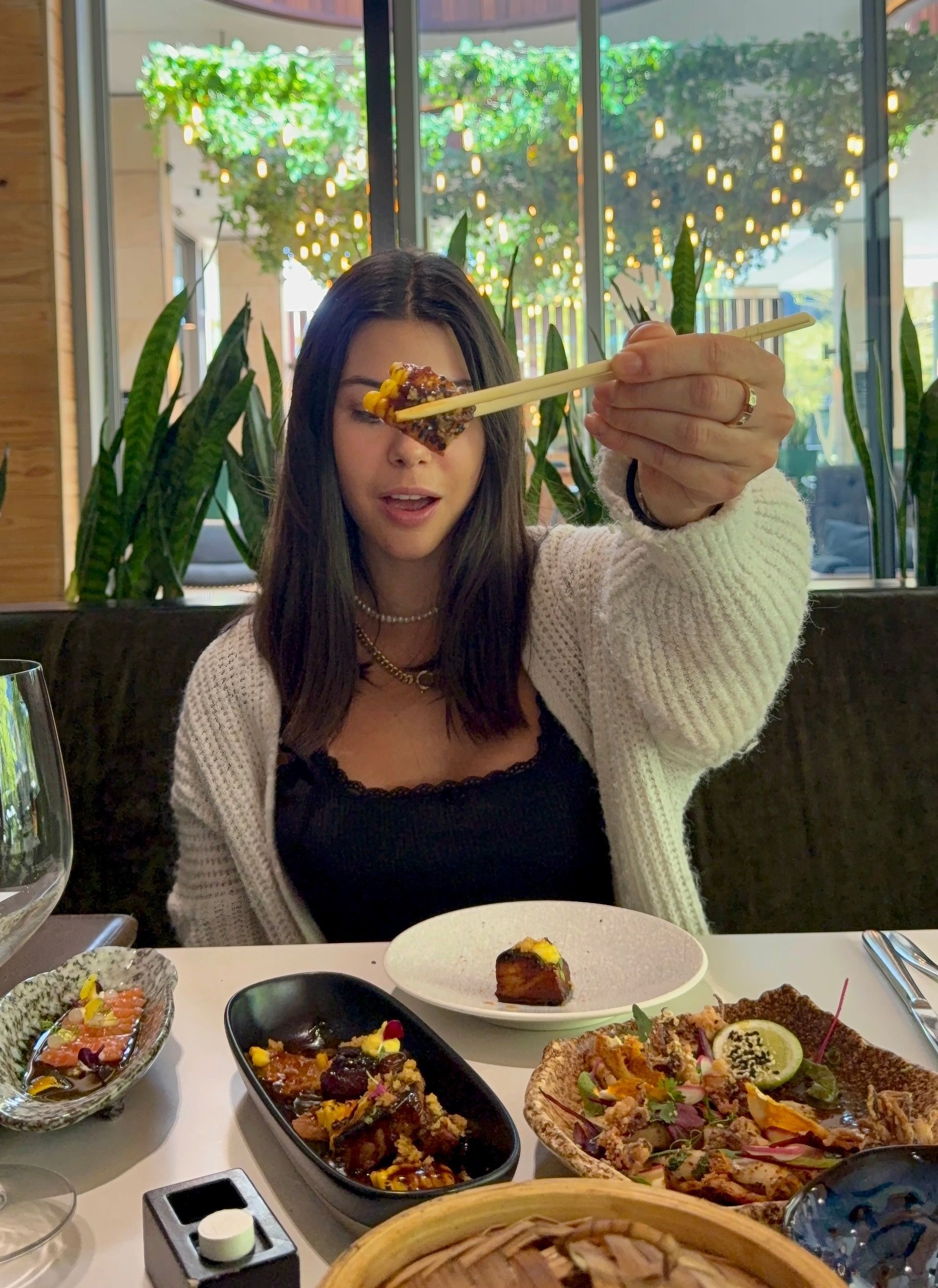 Paige is tasting sticky ginger-soy pork belly at Urban Umami, glazed and caramelised with charred corn