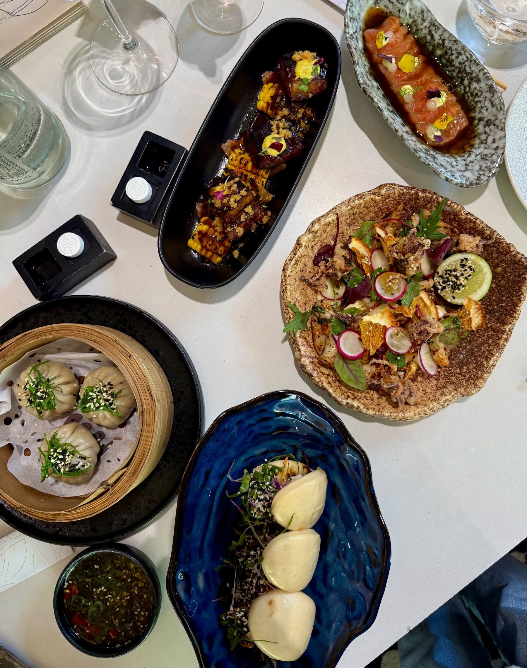 Selection of bao buns, calamari, salmon sashimi, beef dim sum and sticky pork belly served at Urban