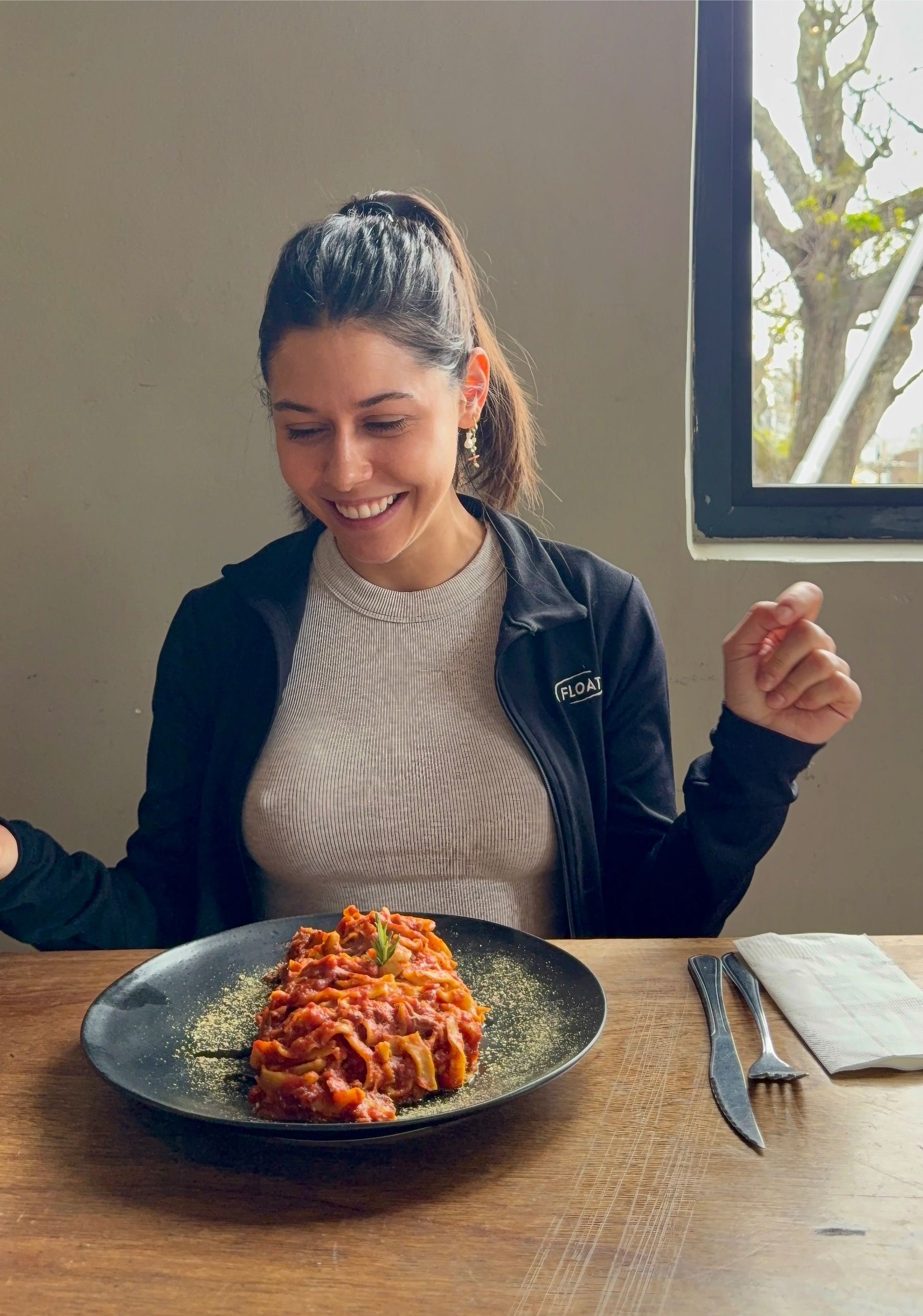Paige smiling at a plate of freshly made pasta at Woodlands Eatery, Cape Town
