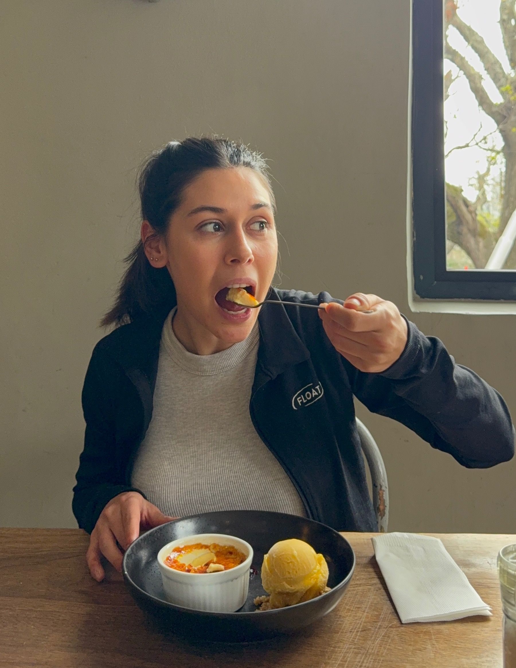 Paige about to take a bite of crème brûlée dessert at Woodlands Eatery in Cape Town