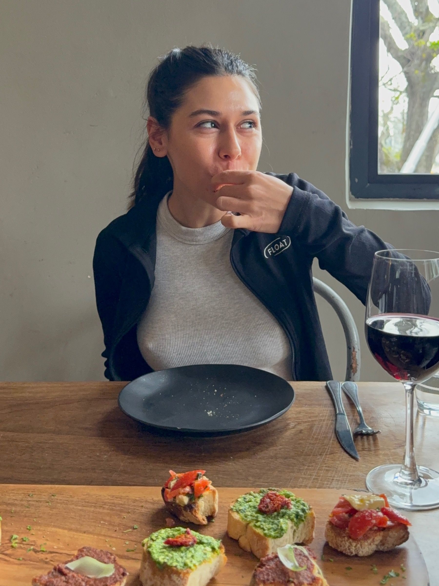 Paige tasting bruschetta starter topped with tomato and herbs at Woodlands Eatery in Cape Town