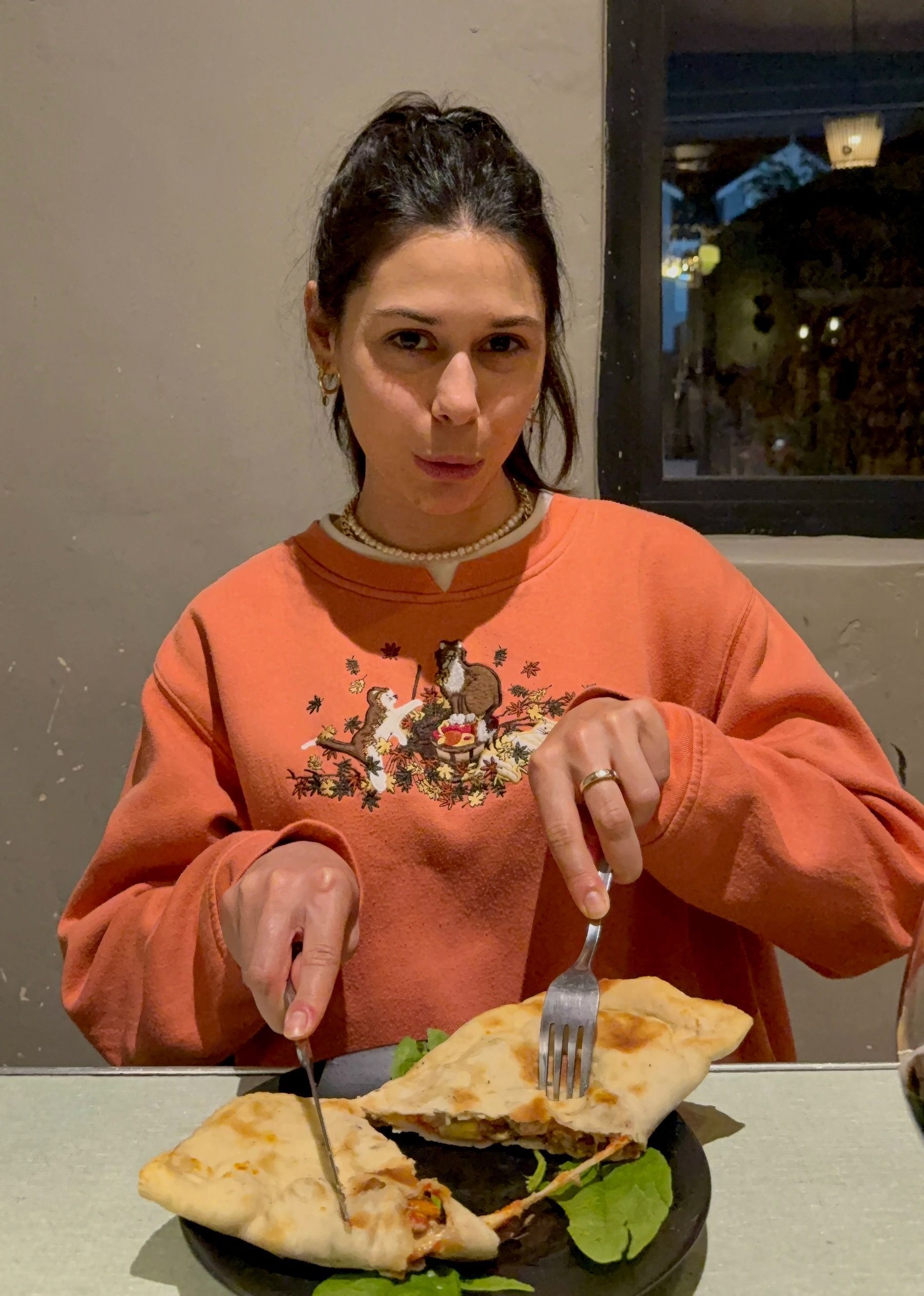 Paige cutting into a freshly baked calzone at The Woodlands Eatery in Cape Town.