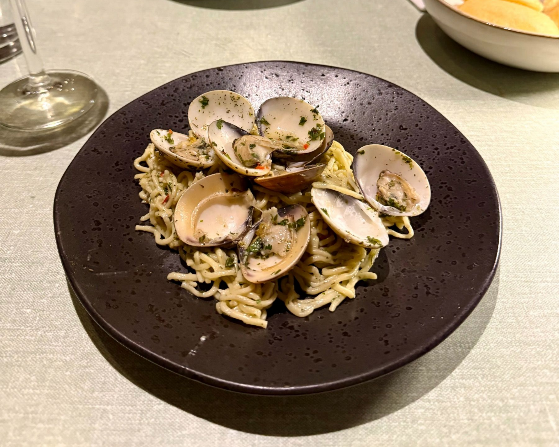Clam pasta in a dark bowl at The Woodlands Eatery during a Zevenwacht wine pairing dinner.