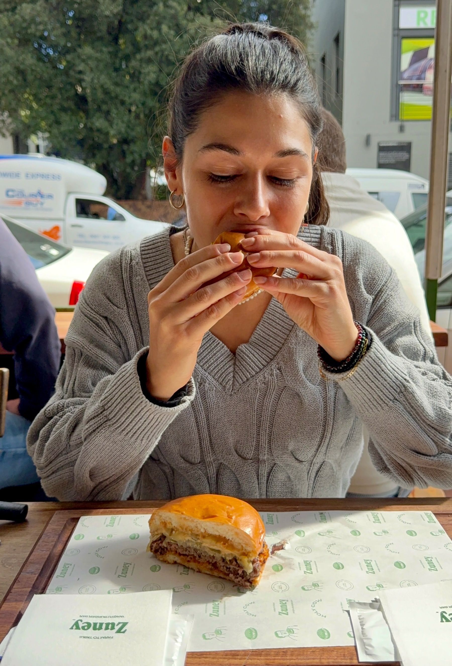Close-up of Paige eating cheeseburger at Zuney
