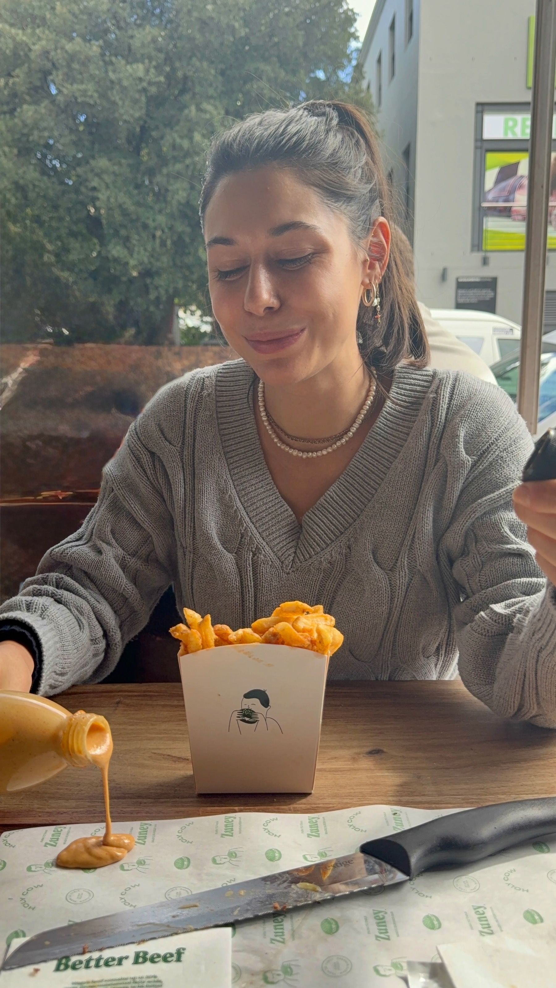 Pouring Zuney secret sauce, crispy fries at Cape Town burger spot