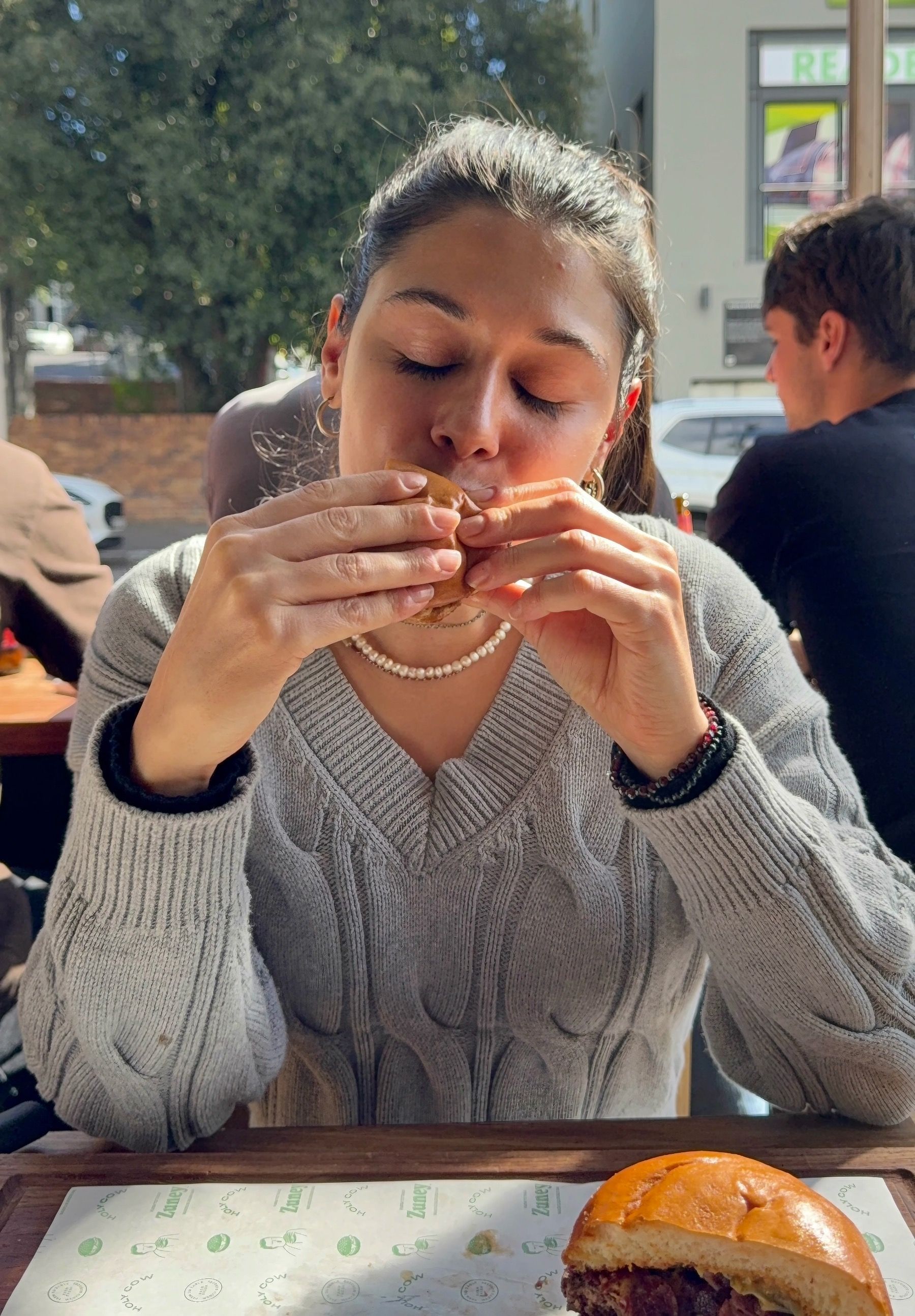 Paige biting into burger at Zuney Cape Town