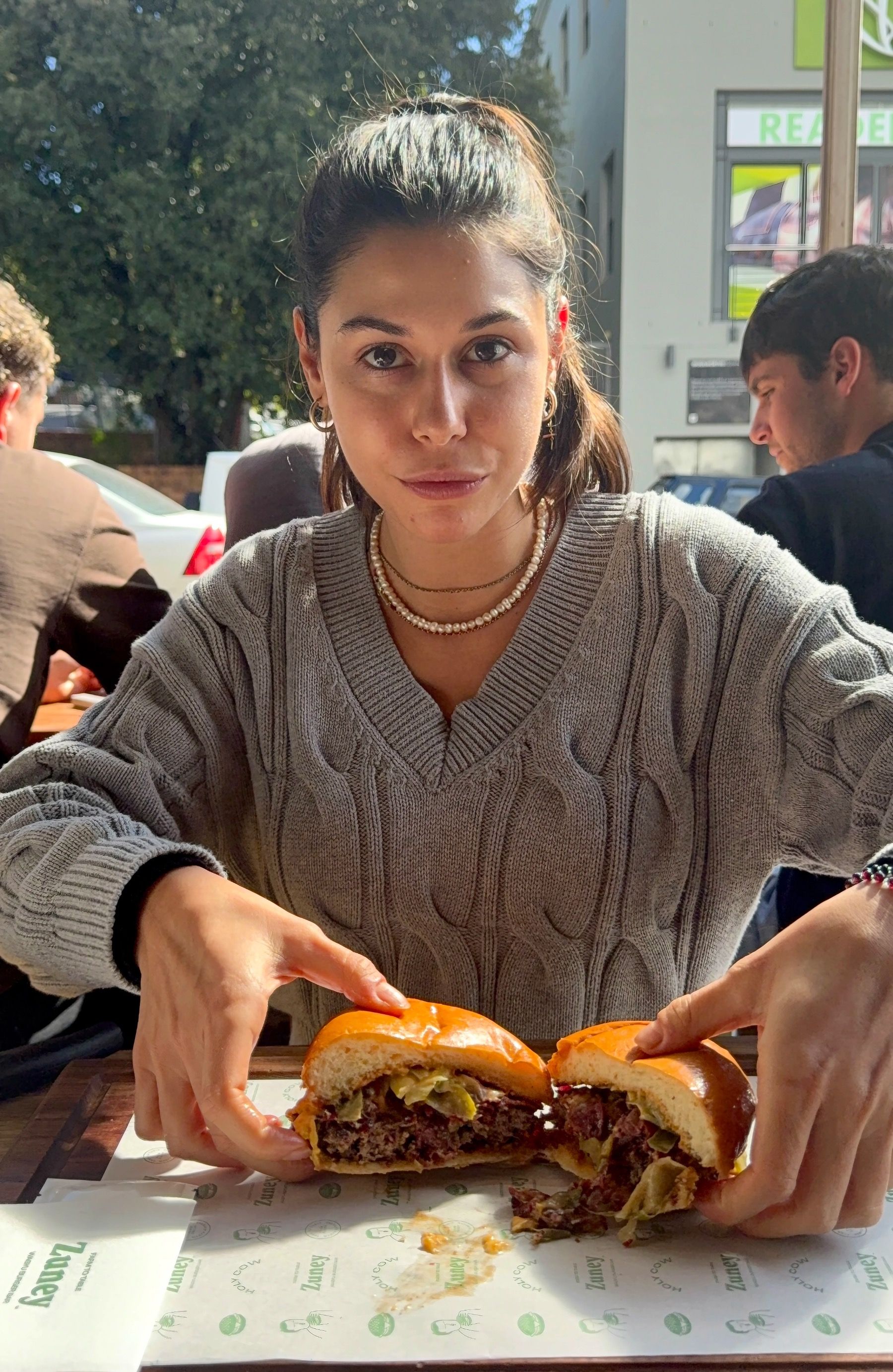 Paige pulling apart bacon cheeseburger at Zuney Cape Town