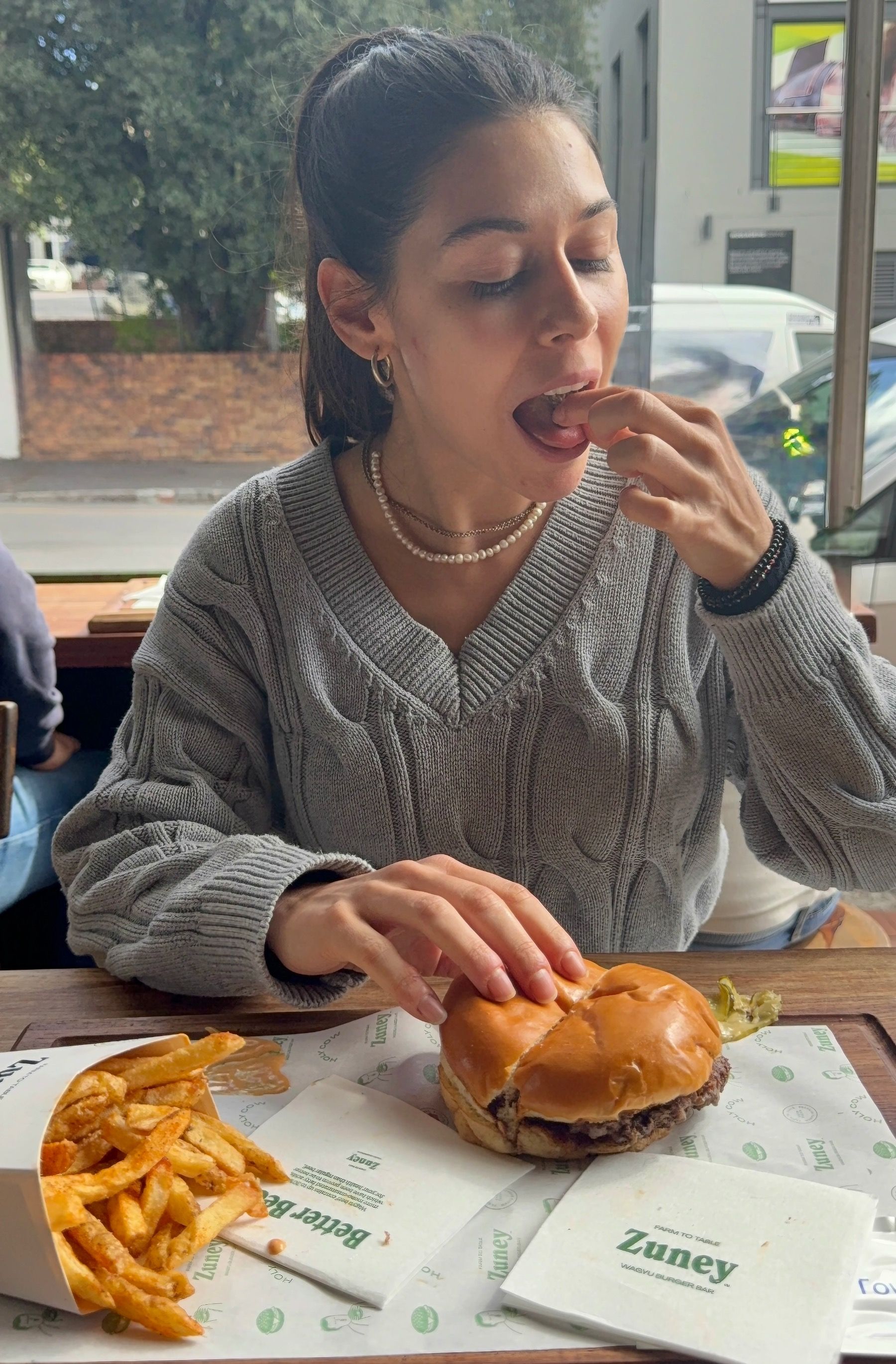 Paige enjoying crispy fries at Zuney burger spot