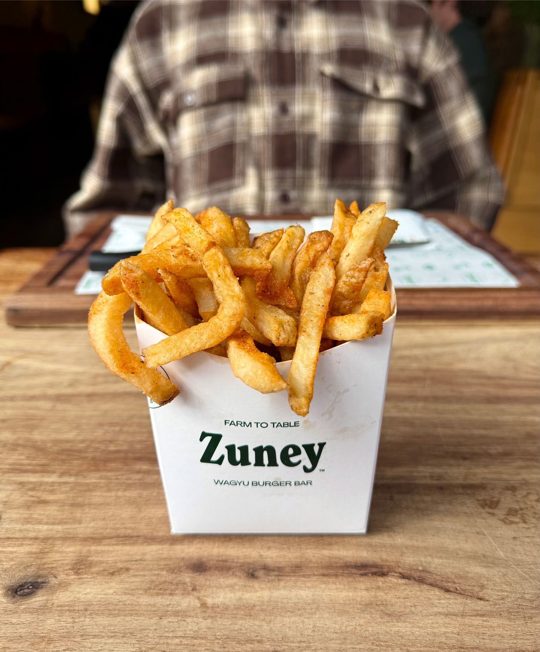 Classic salted fries in Zuney branded cup on wooden table