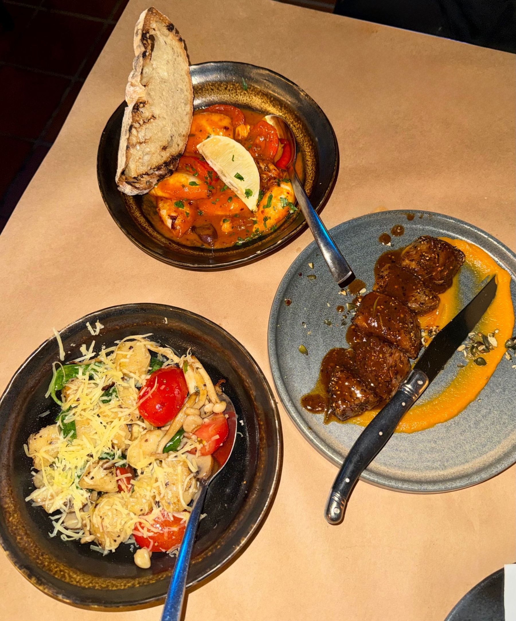 Bouchon Bistro small plates including gnocchi, ostrich with purée and calamari  in pomodoro sauce