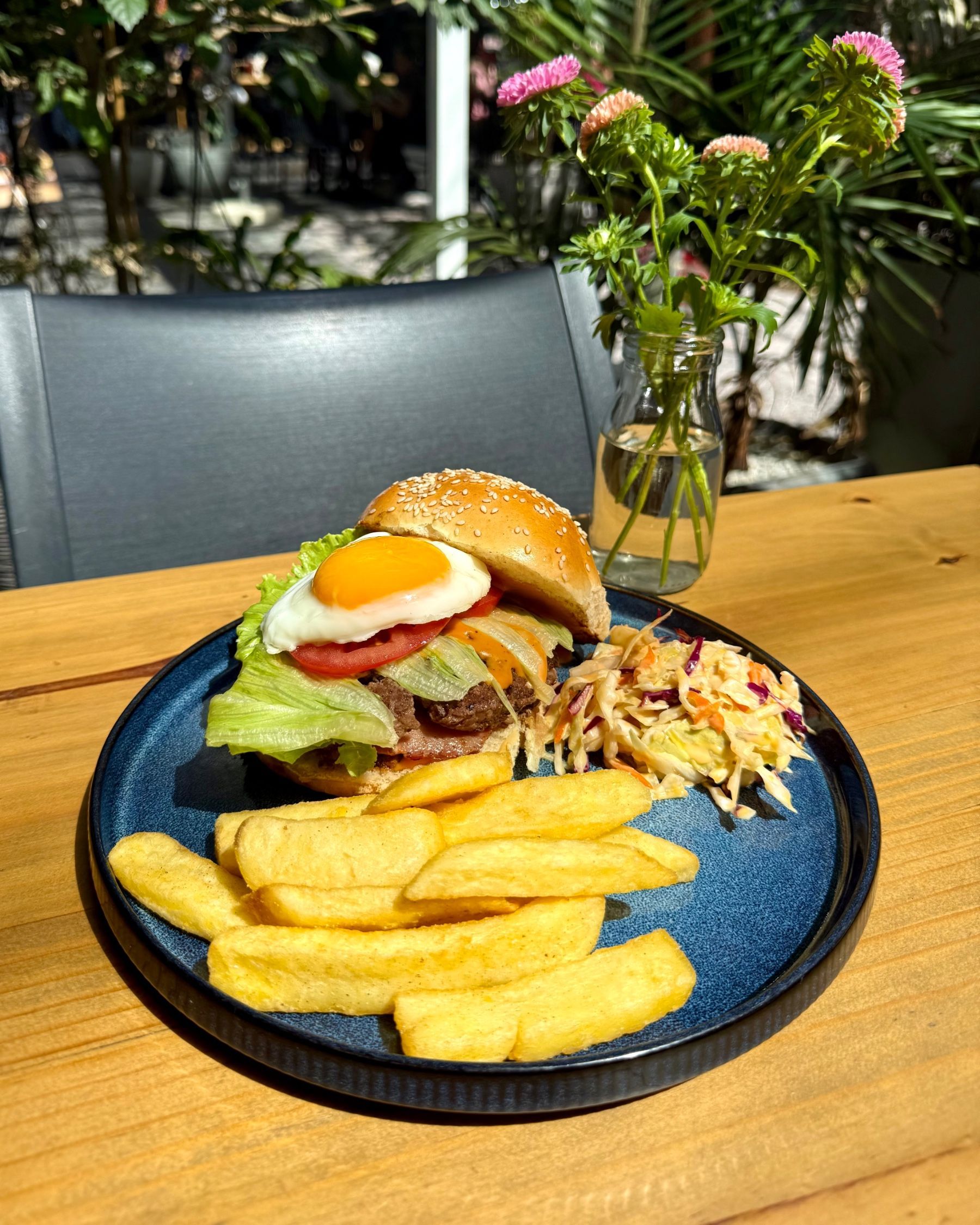 Yumcious beef burger with fried egg and chips served on toasted bun