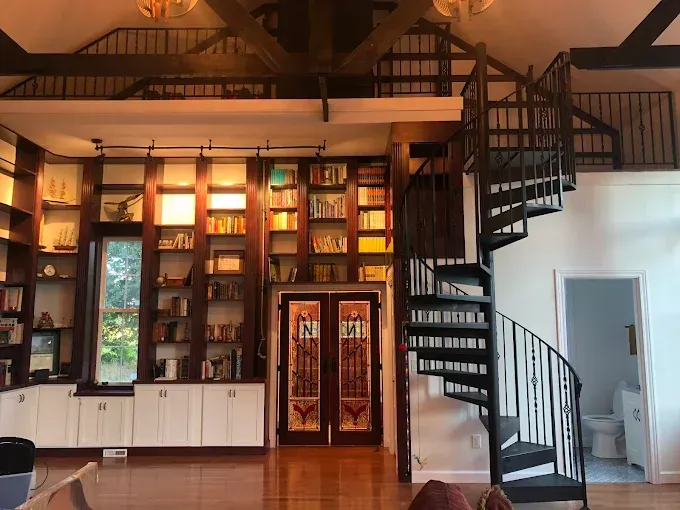 A living room with a spiral staircase leading to the second floor