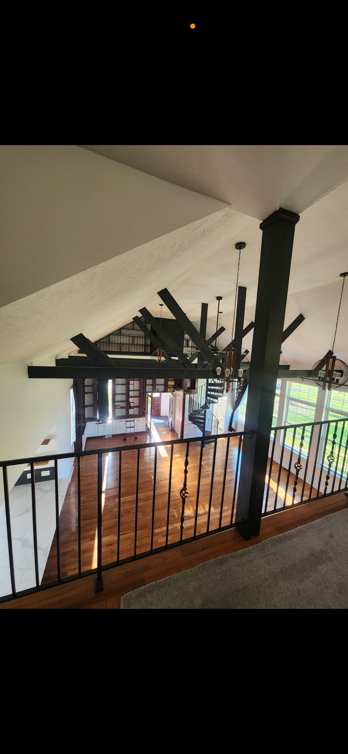 A room with a staircase leading to the second floor and a railing.