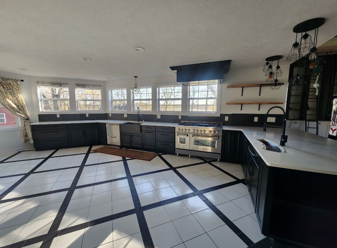 A large kitchen with black and white tiles and a stove.