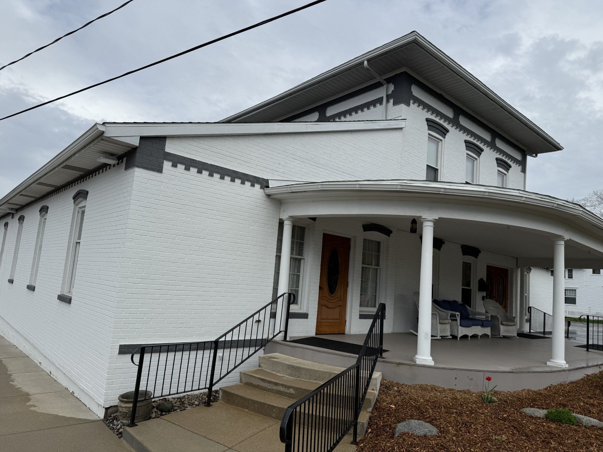 A large white house with a porch and stairs