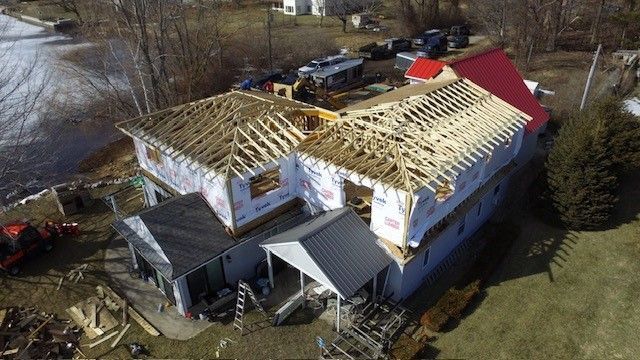 An aerial view of a house under construction with a red roof.