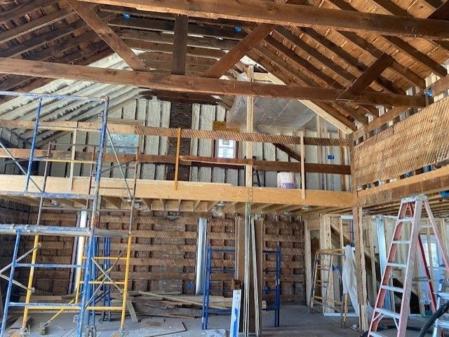 The inside of a building under construction with scaffolding and ladders.