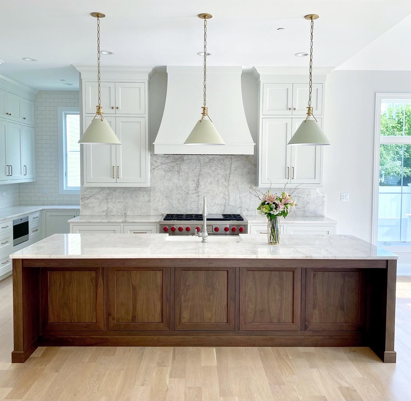 A kitchen with white cabinets and a large island