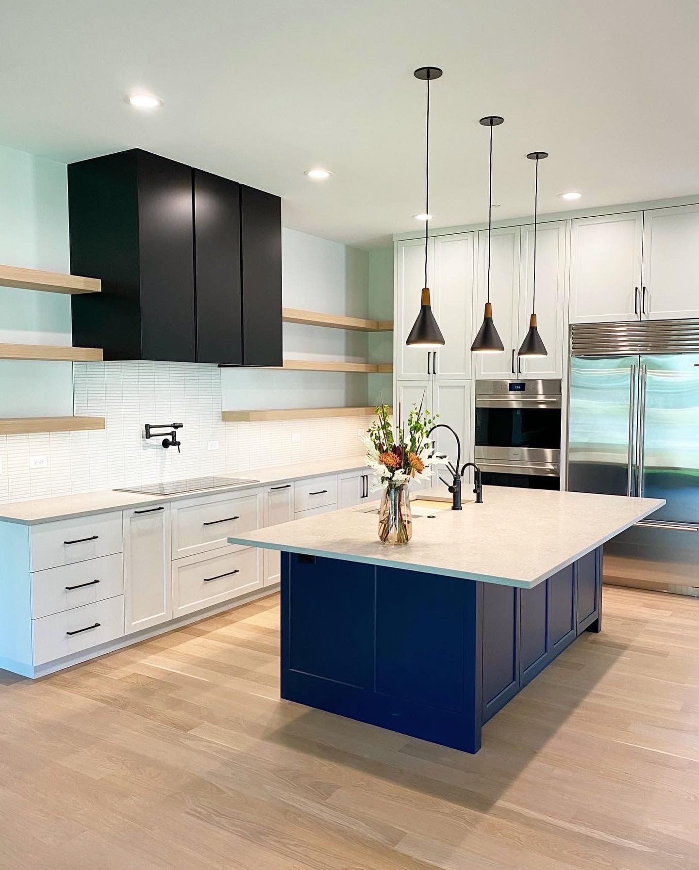 A kitchen with a large blue island in the middle.