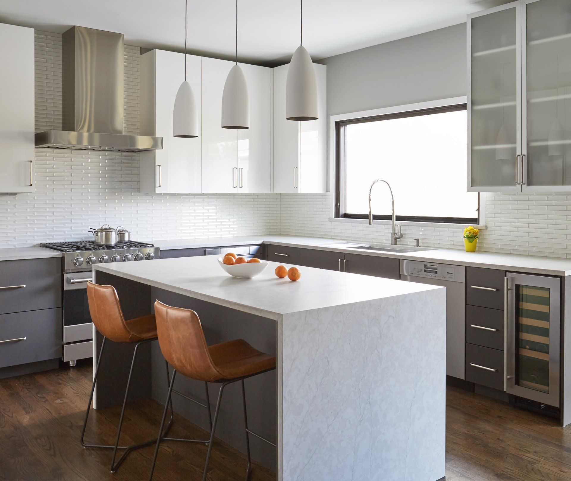 A kitchen with a large island and two chairs