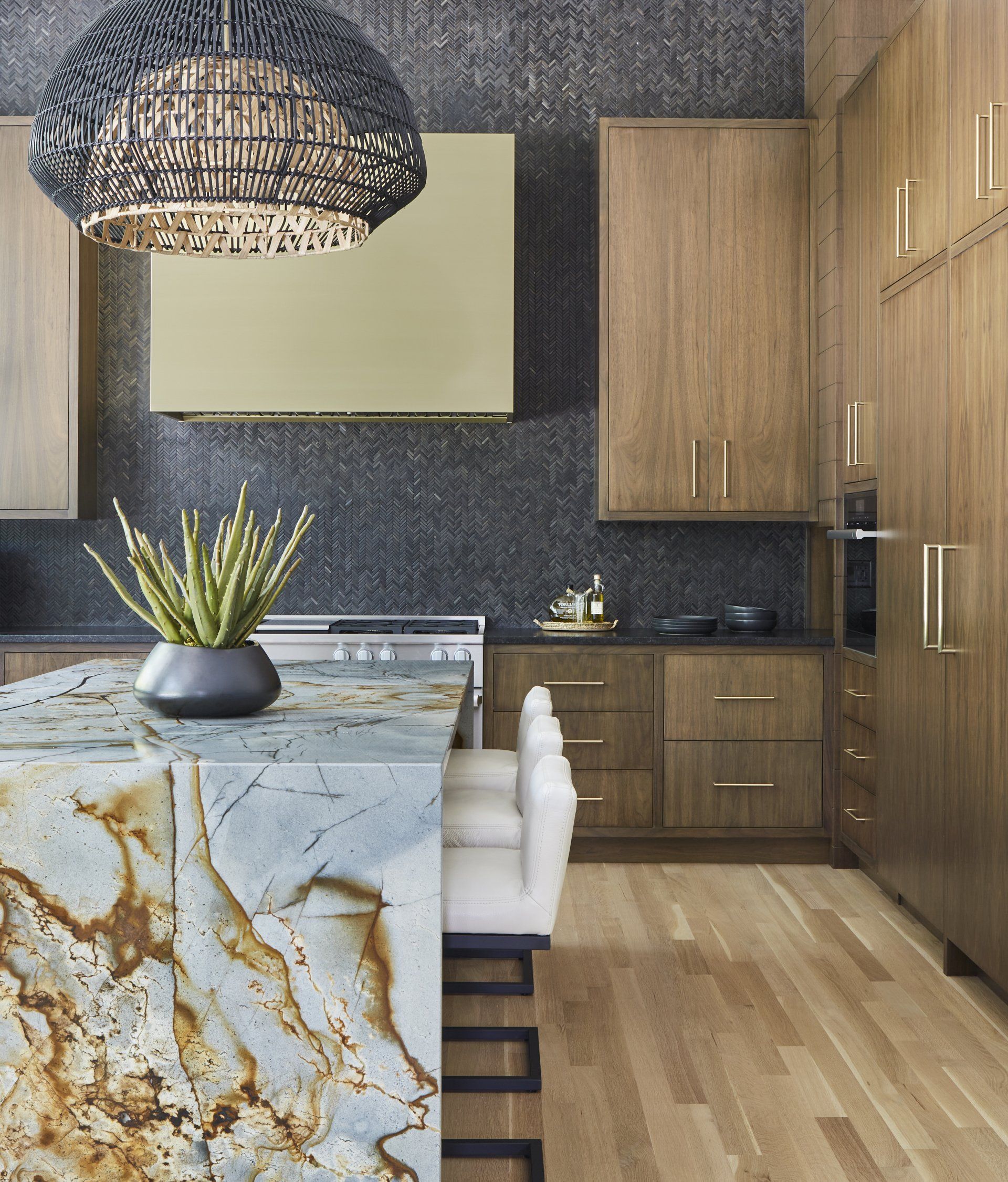 A kitchen with a marble counter top and wooden cabinets
