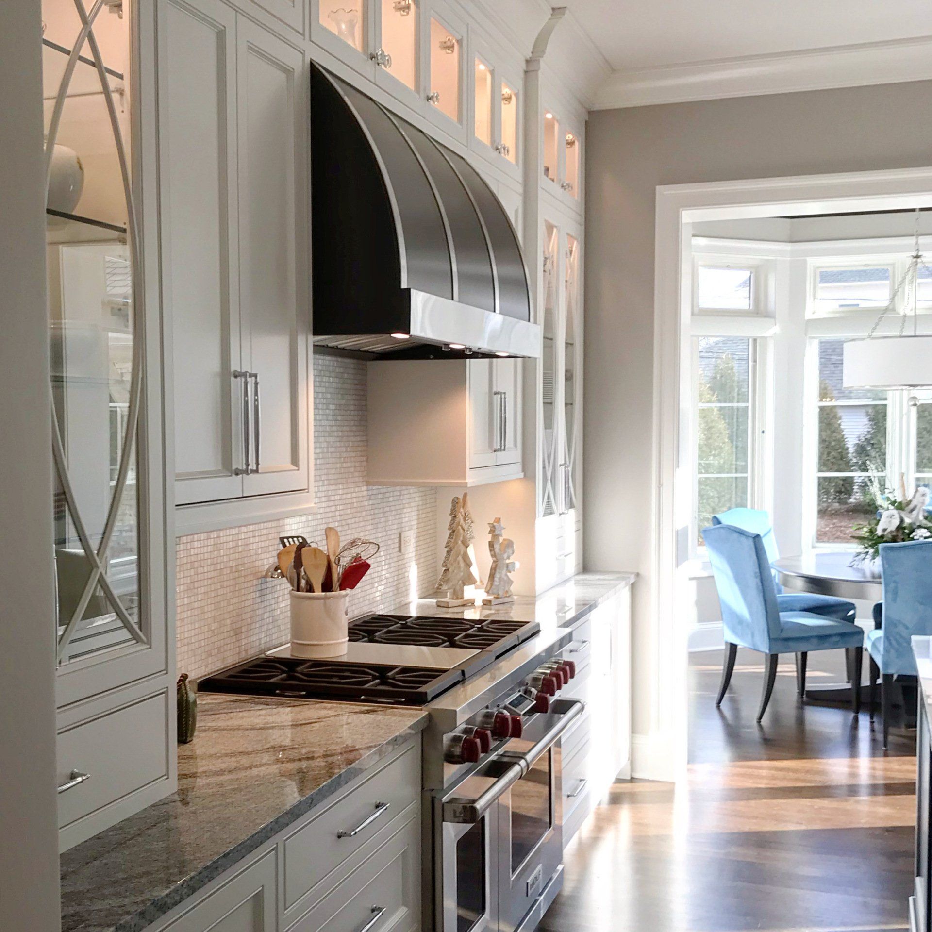 A kitchen with white cabinets and a stove top oven
